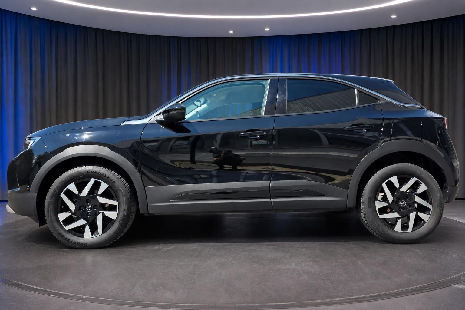 Opel SUV schwarz Seitenansicht in Ausstellungsraum mit Felgen