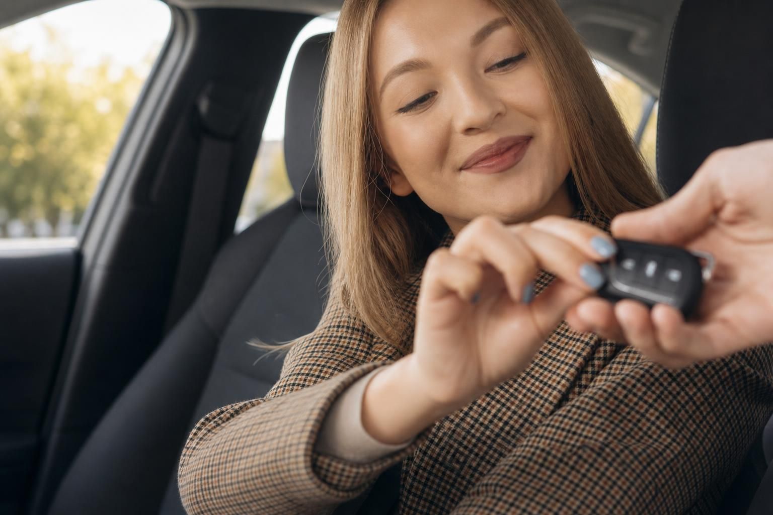 Frau mit Smartphone im Auto Innenraum - Beifahrersitz