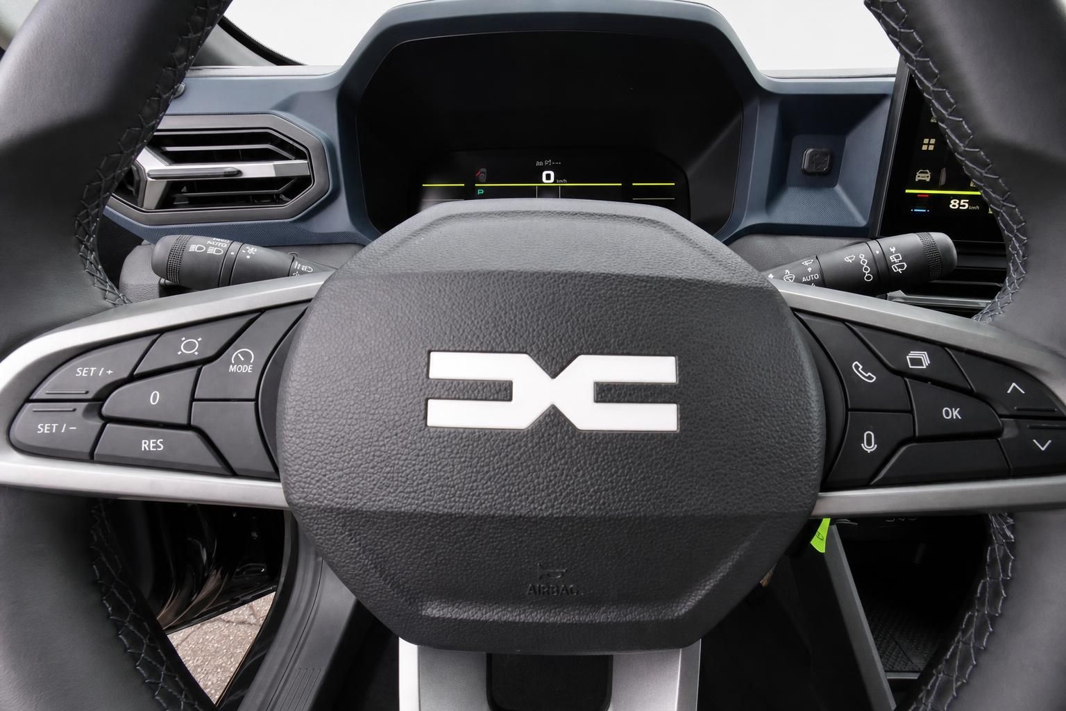Lenkrad mit Dacia Logo und Multifunktionstasten im Cockpit