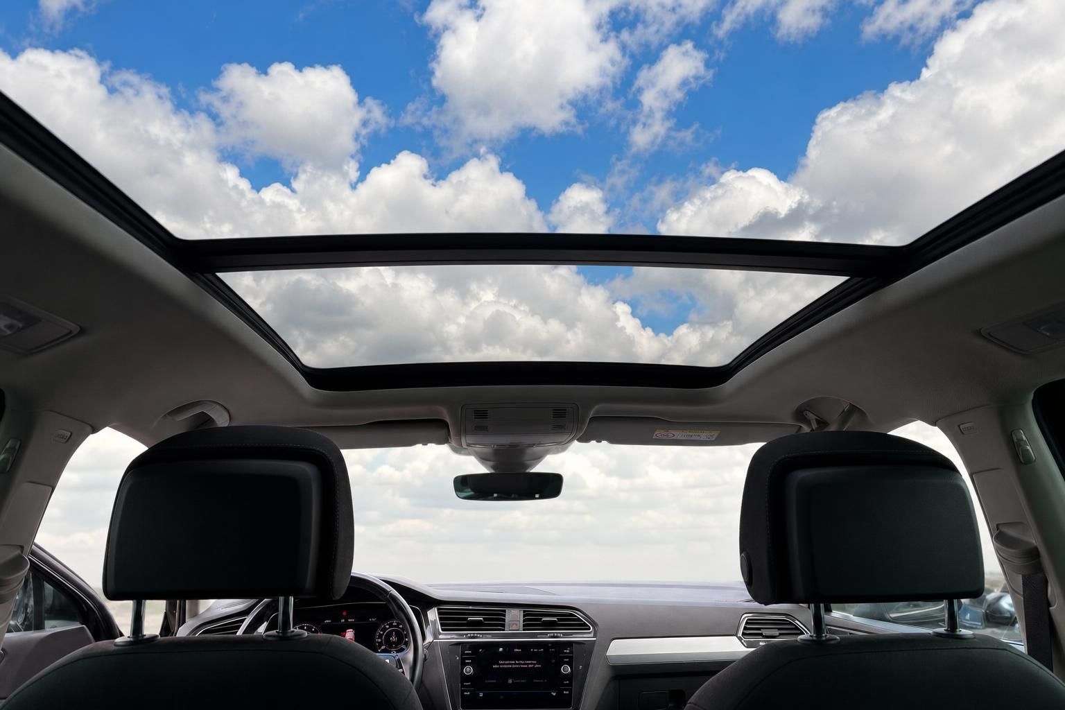 VW Innenraum mit grossem Panorama-Schiebedach und Blick zum Himmel