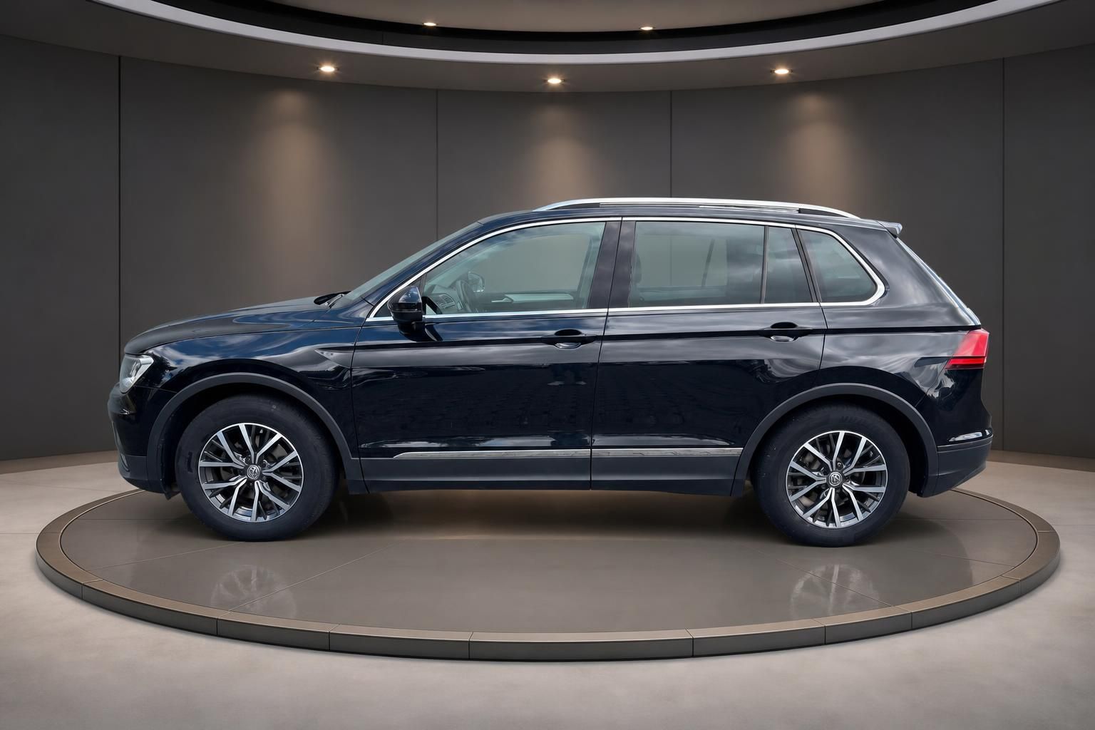 VW Tiguan schwarz Seitenansicht auf Drehbühne im Showroom