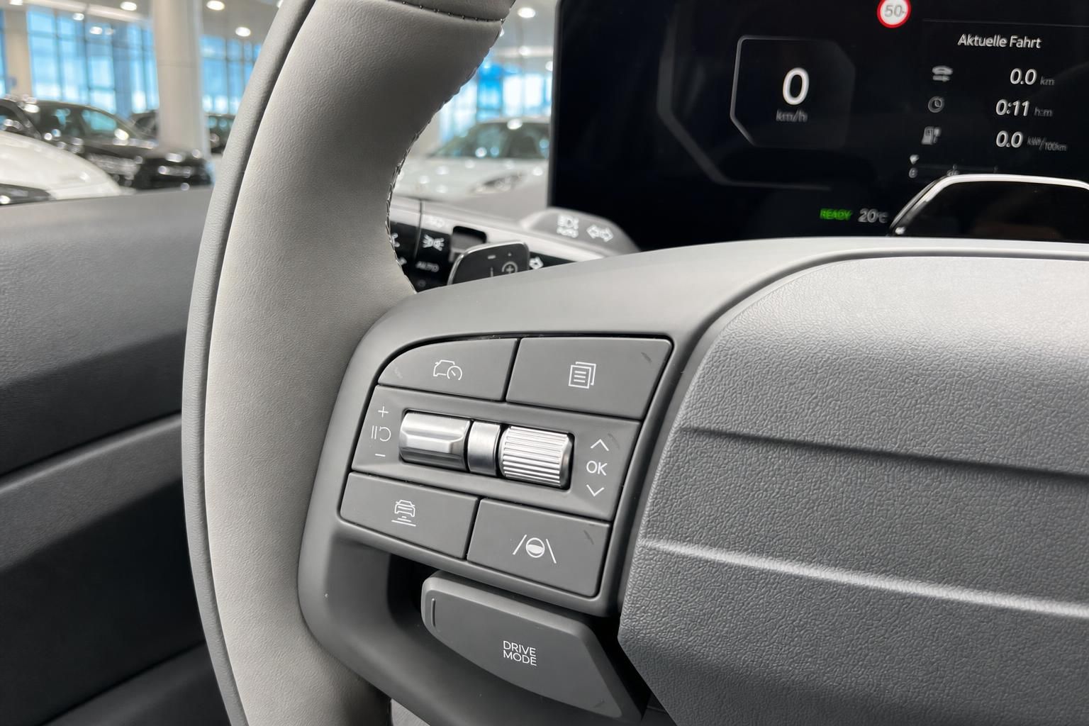 Lenkrad mit Bedientasten und digitalem Tacho im Fahrzeuginnenraum