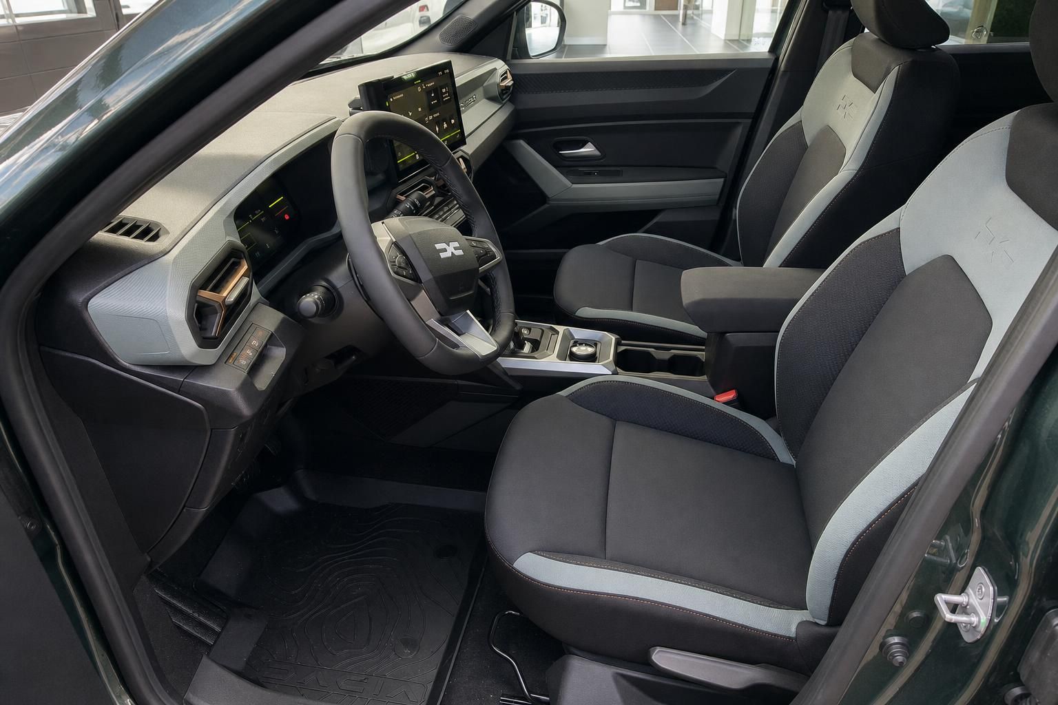 Dacia Duster Fahrerplatz mit grau-weißer Sitzausstattung und modernem Interieur