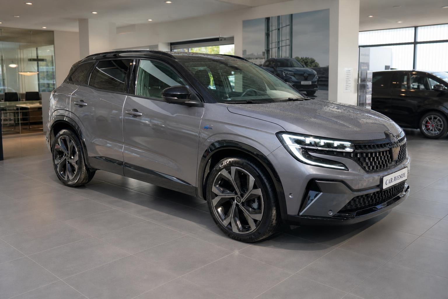 Renault Austral grau, Frontansicht seitlich im Autohaus Showroom