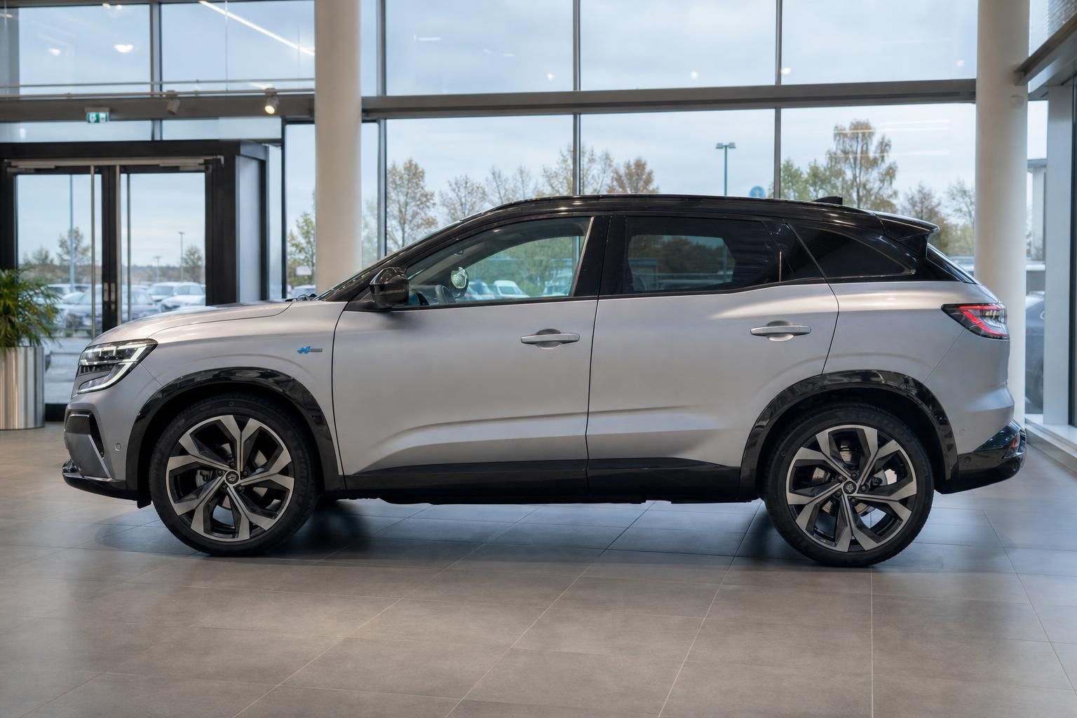 Renault Austral in Silber, Seitenansicht im Autohaus-Showroom