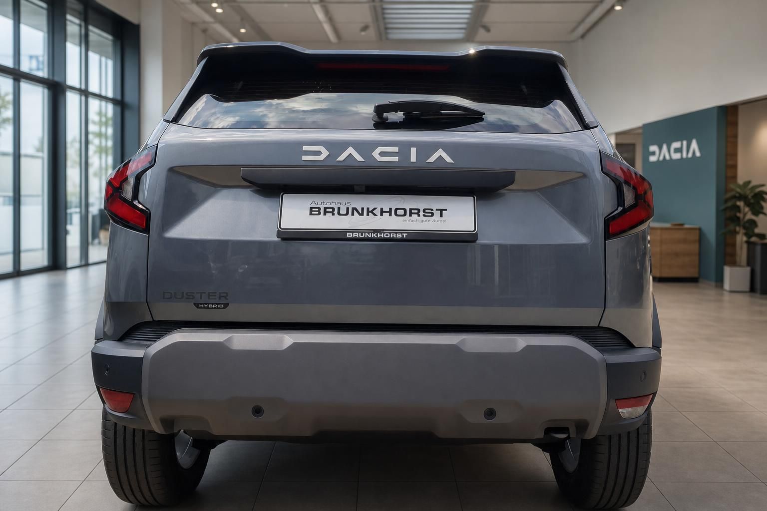 Dacia Duster Hybrid - Heckansicht mit DACIA-Schriftzug und Kennzeichenhalter im Autohaus