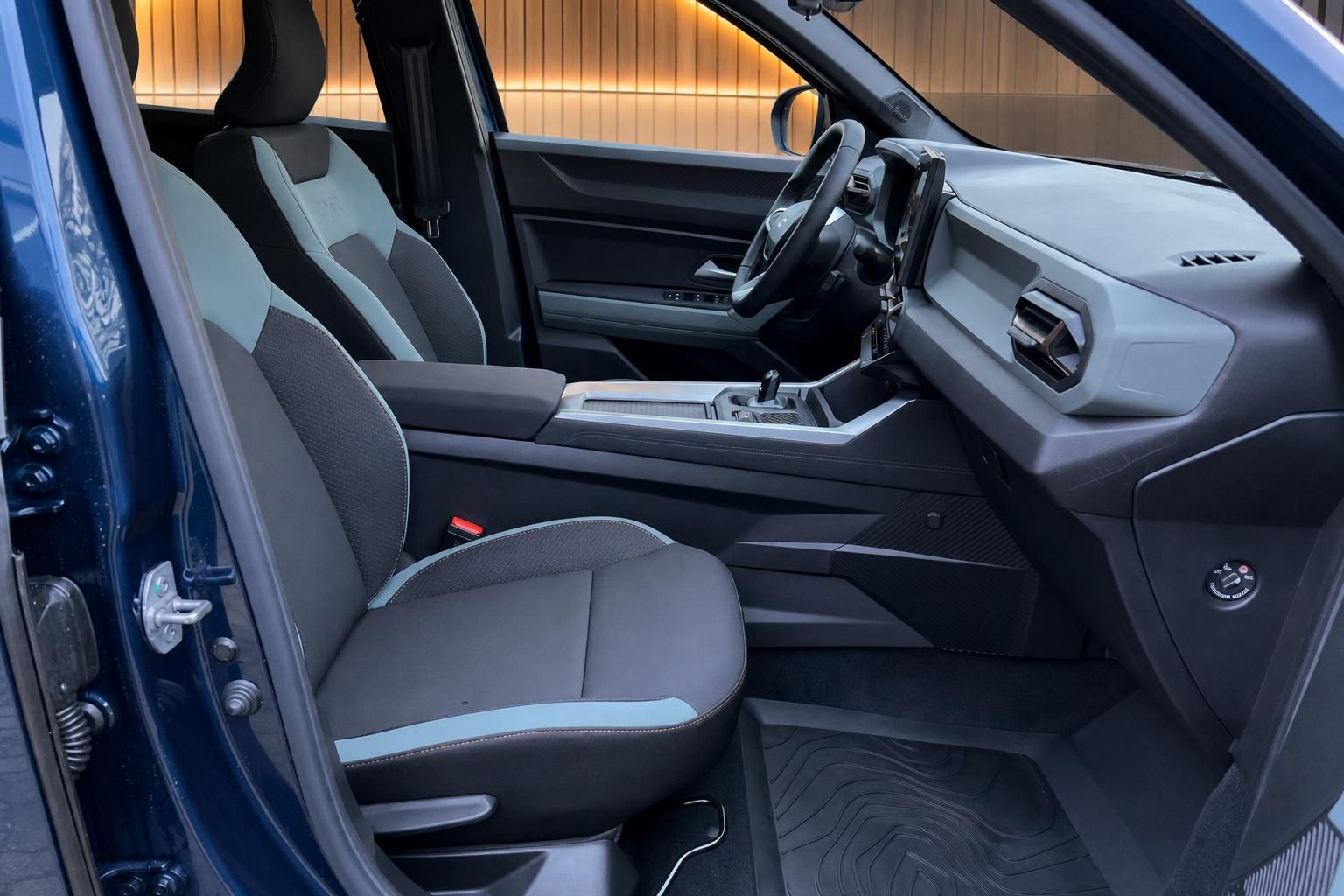 Fahrzeuginnenraum mit grauen Sitzen, Mittelkonsole und Schaltknauf in blauem Auto