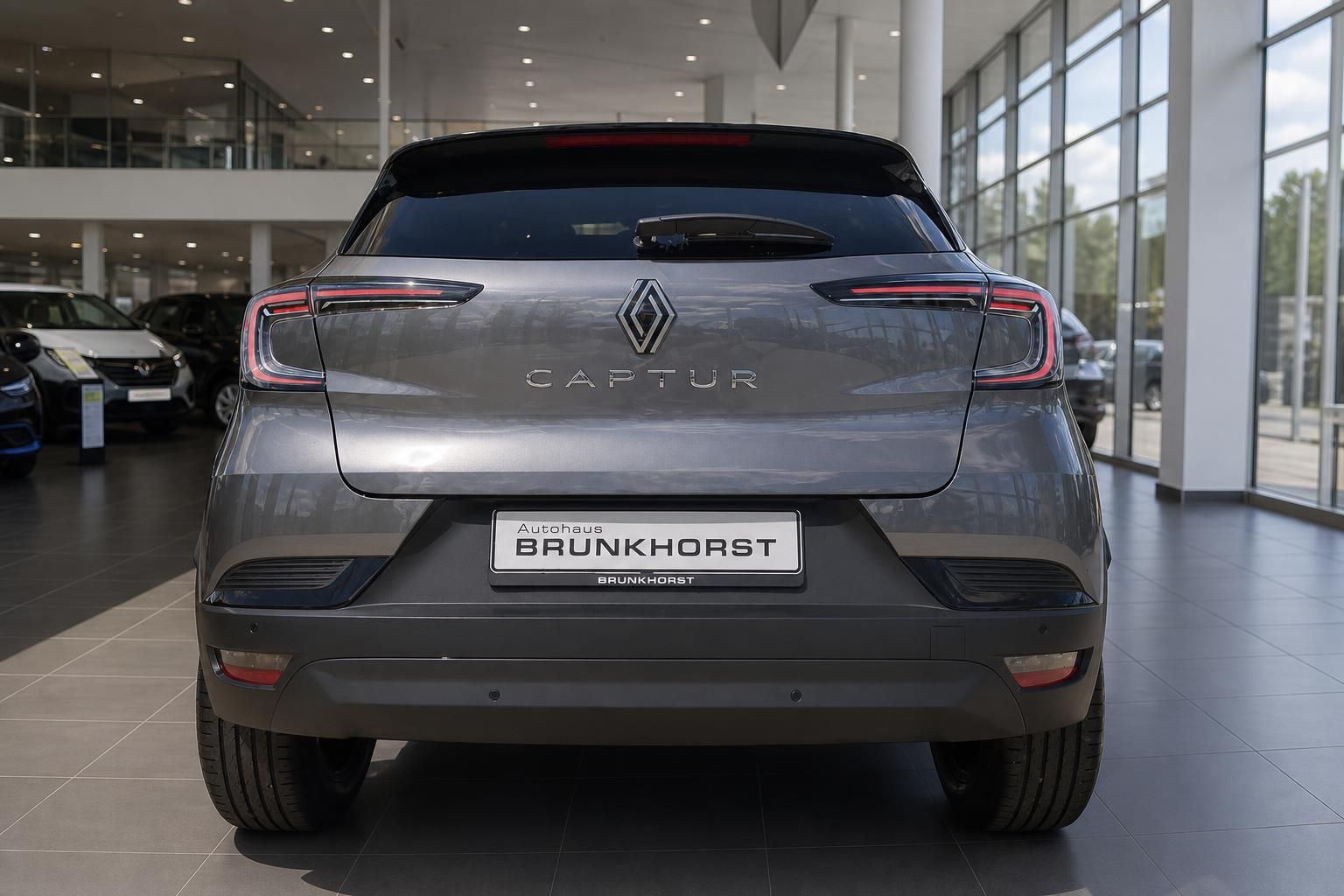 Renault Captur grau metallic Heckansicht im Autohaus - modernes Elektro-SUV