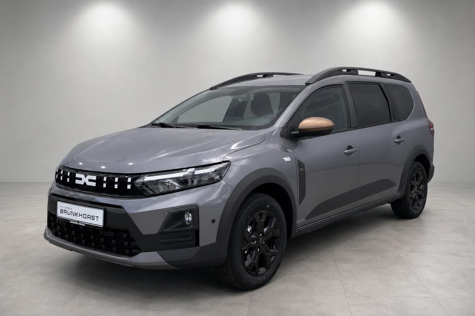 Grauer Dacia Jogger Kompakt-SUV Seitenansicht im Autohaus Brunkhorst Showroom