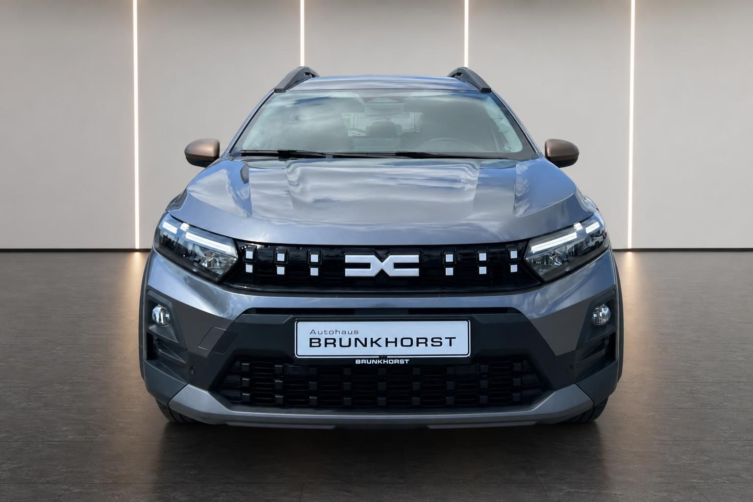 Grauer Dacia Jogger Frontansicht mit charakteristischem Kühlergrill und LED-Scheinwerfern