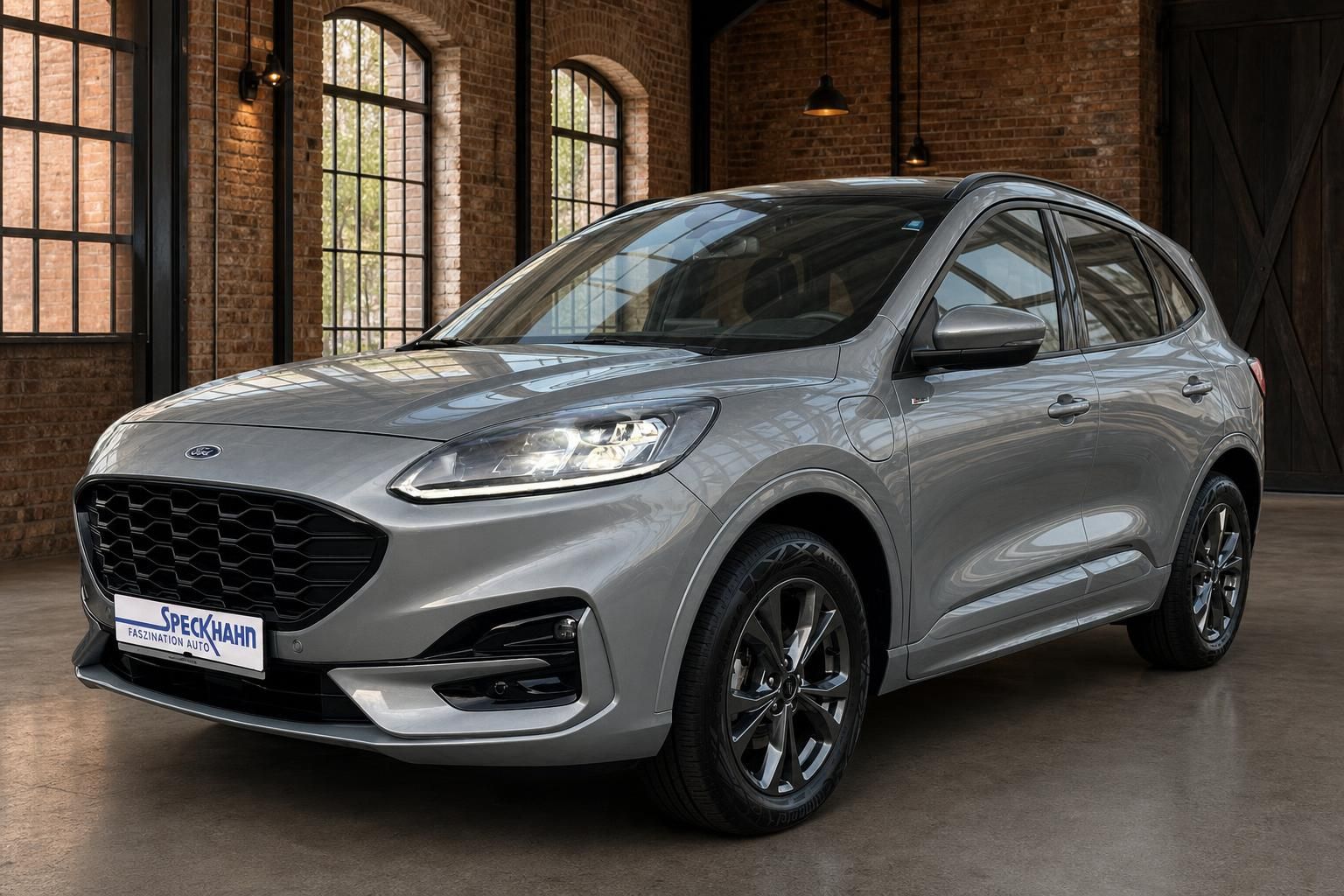 Ford Kuga grau Frontansicht schräg in Loft mit Backsteinmauer