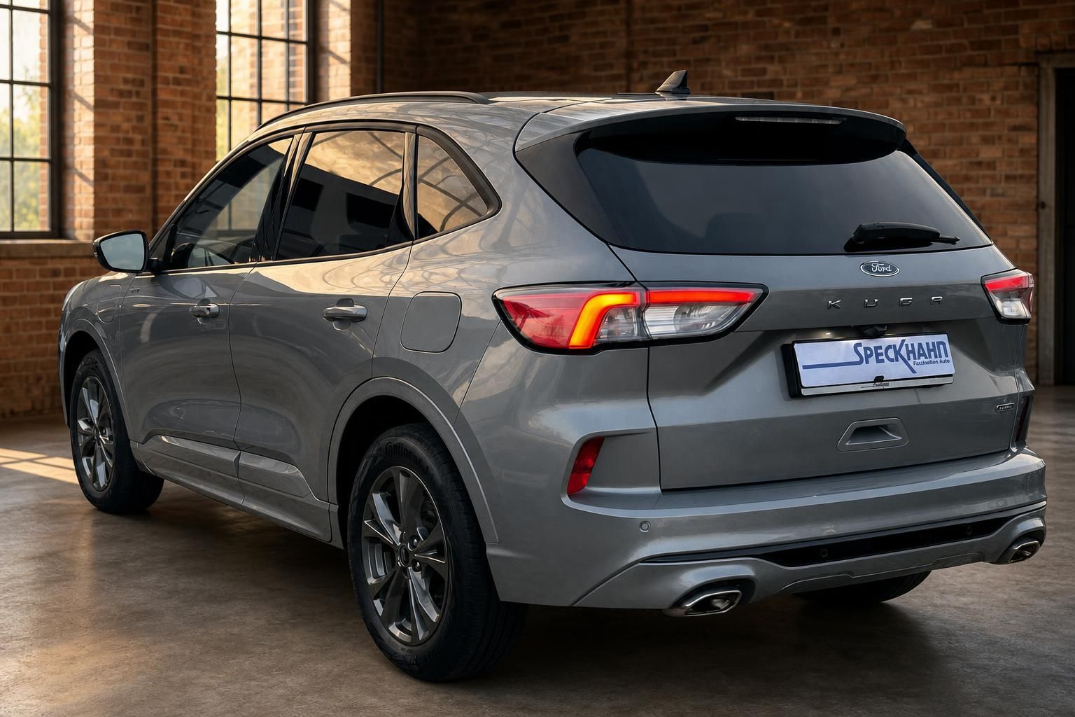 Ford Kuga grau Heckansicht seitlich in Halle mit Backsteinwand
