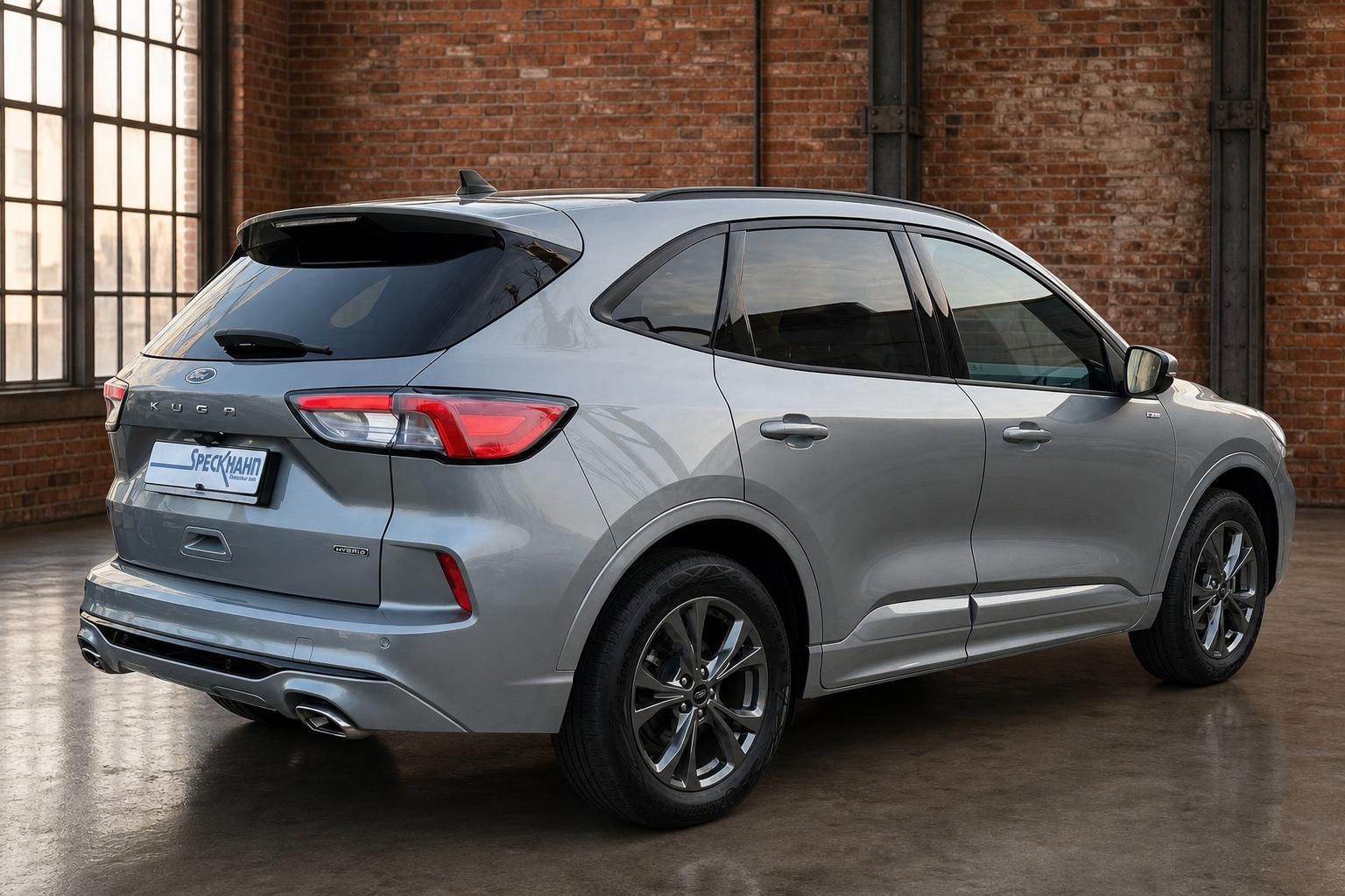 Ford Kuga Hybrid silber Heckansicht schräg in Industriehalle