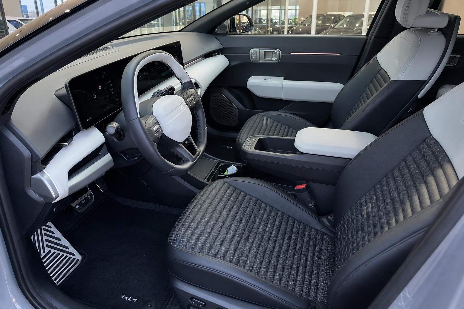Kia Innenraum mit schwarz-weißen Sportsitzen und digitalem Cockpit