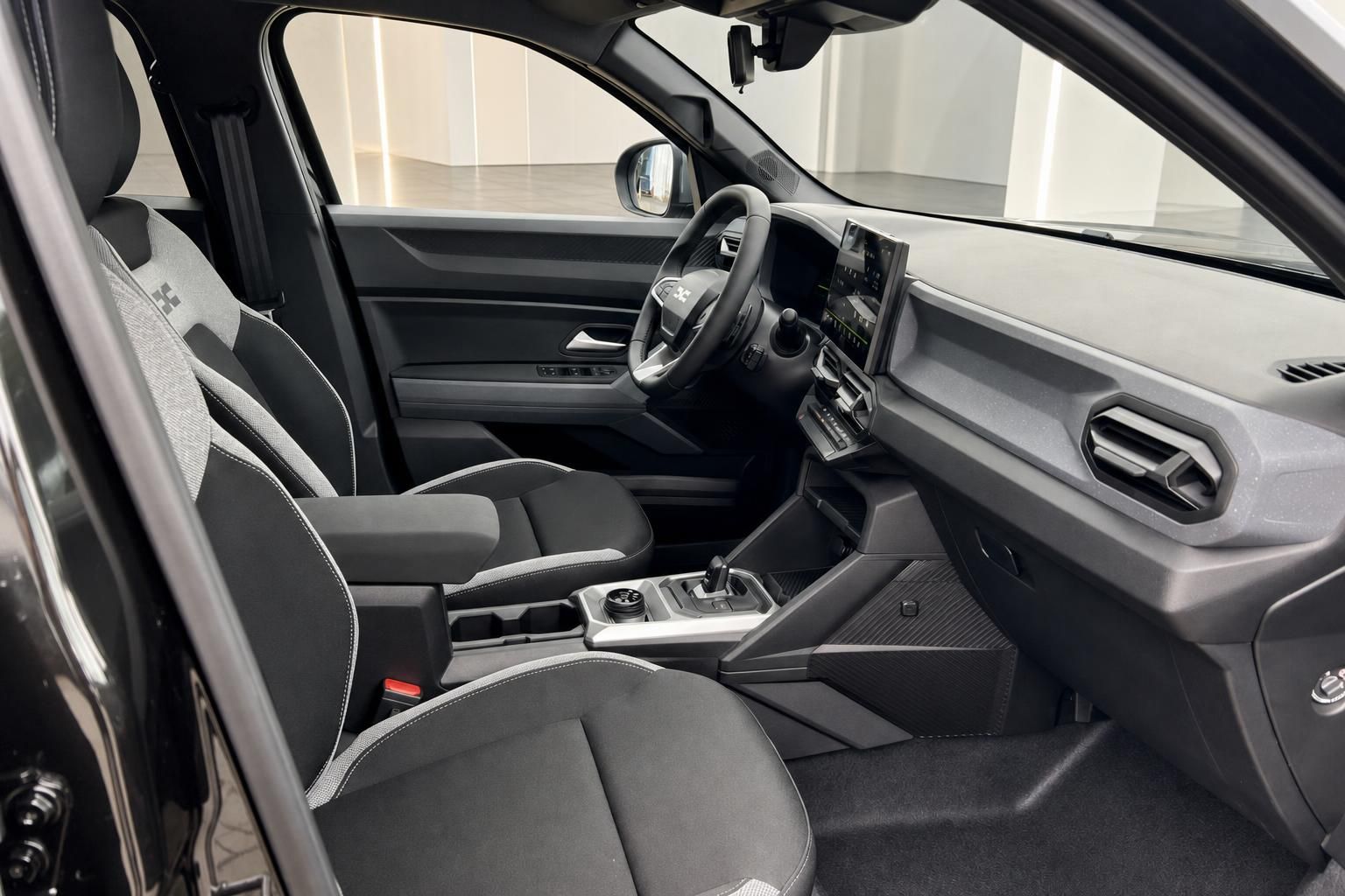 Innenraum Dacia mit Cockpit, Lenkrad und Sitzen in Schwarz-Grau