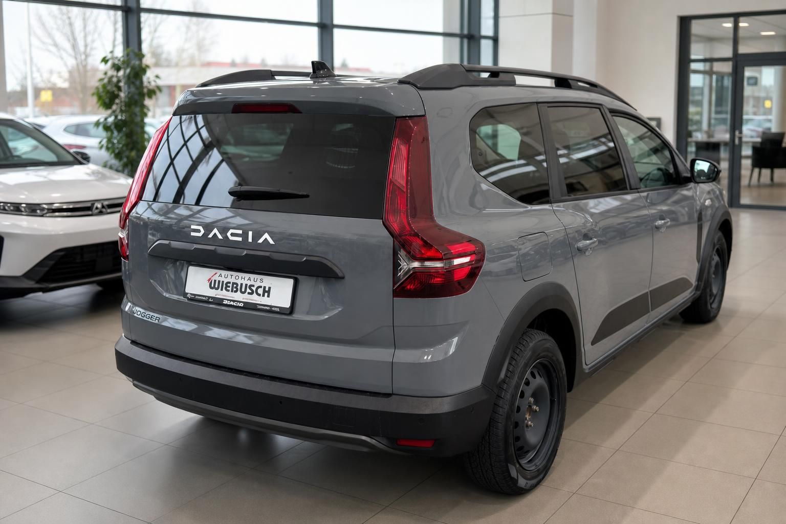 Dacia Lodger SUV in grau, Heckansicht mit AUTOHAUS WIEBUSCH Kennzeichenhalter im Showroom