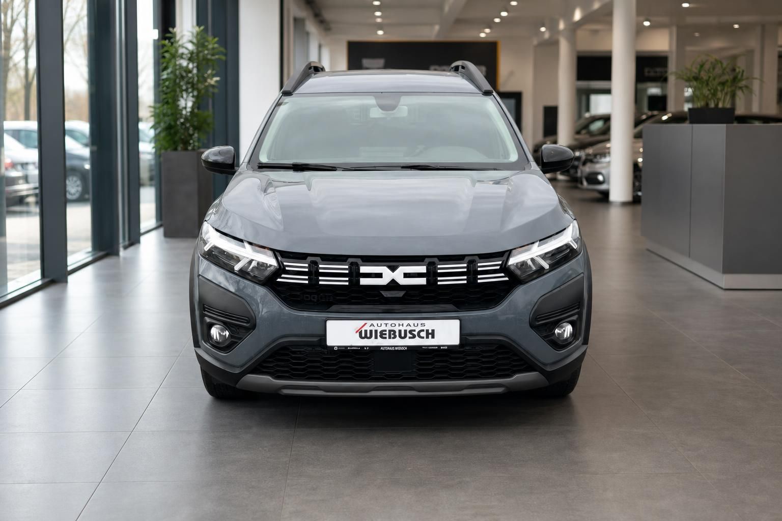 Dacia Jogger grau Frontansicht - moderner Crossover mit LED-Scheinwerfern im Autohaus
