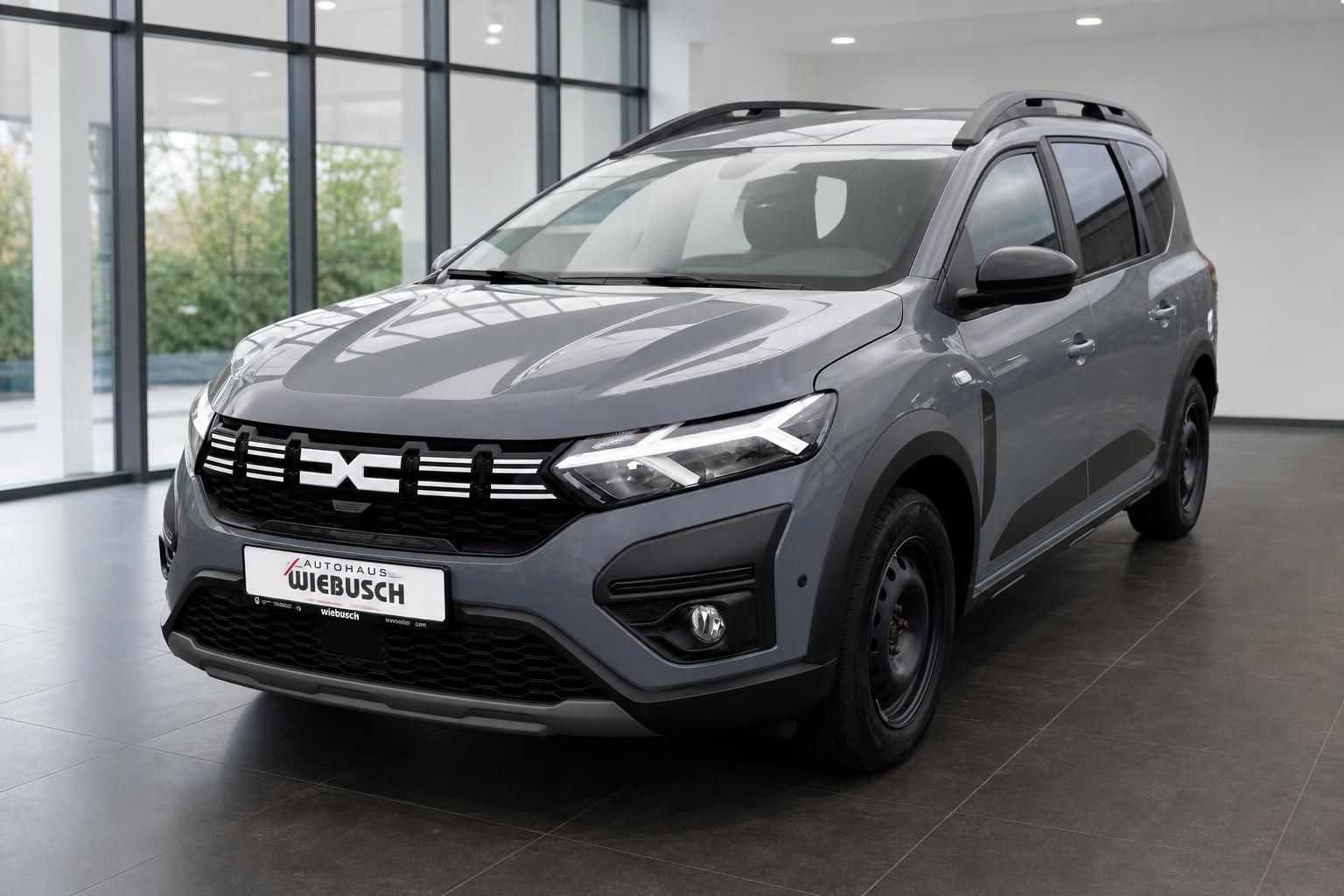 Dacia SUV grau metallic Frontansicht im Autohaus Showroom