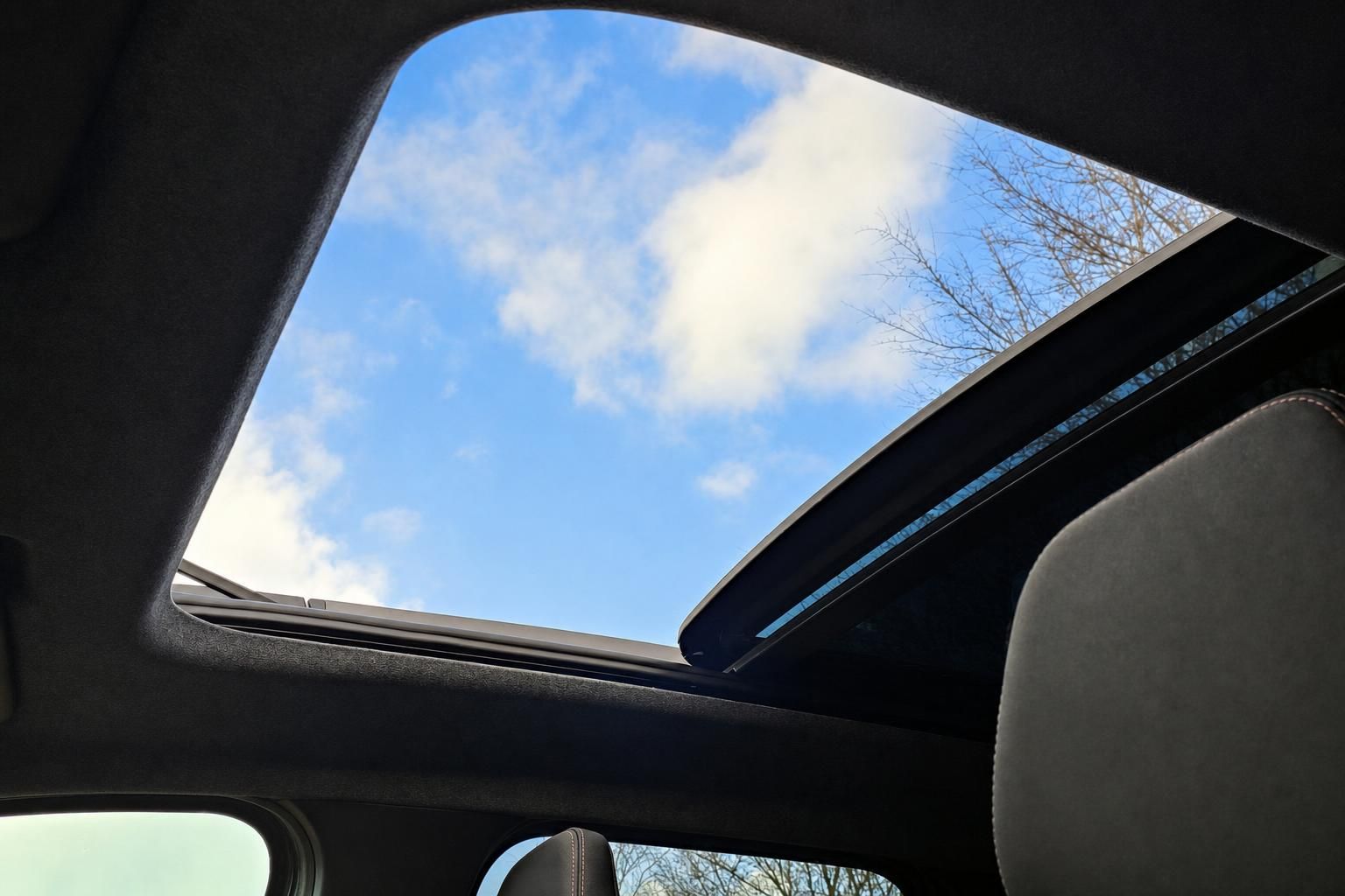 Panorama-Schiebedach im Fahrzeug geöffnet mit Blick auf blauen Himmel