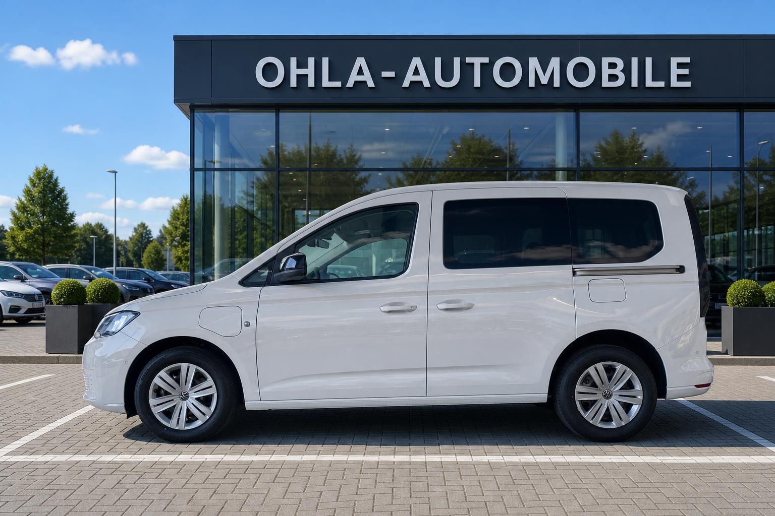 VW Caddy eHybrid weiß Seitenansicht vor Autohaus Ohla-Automobile