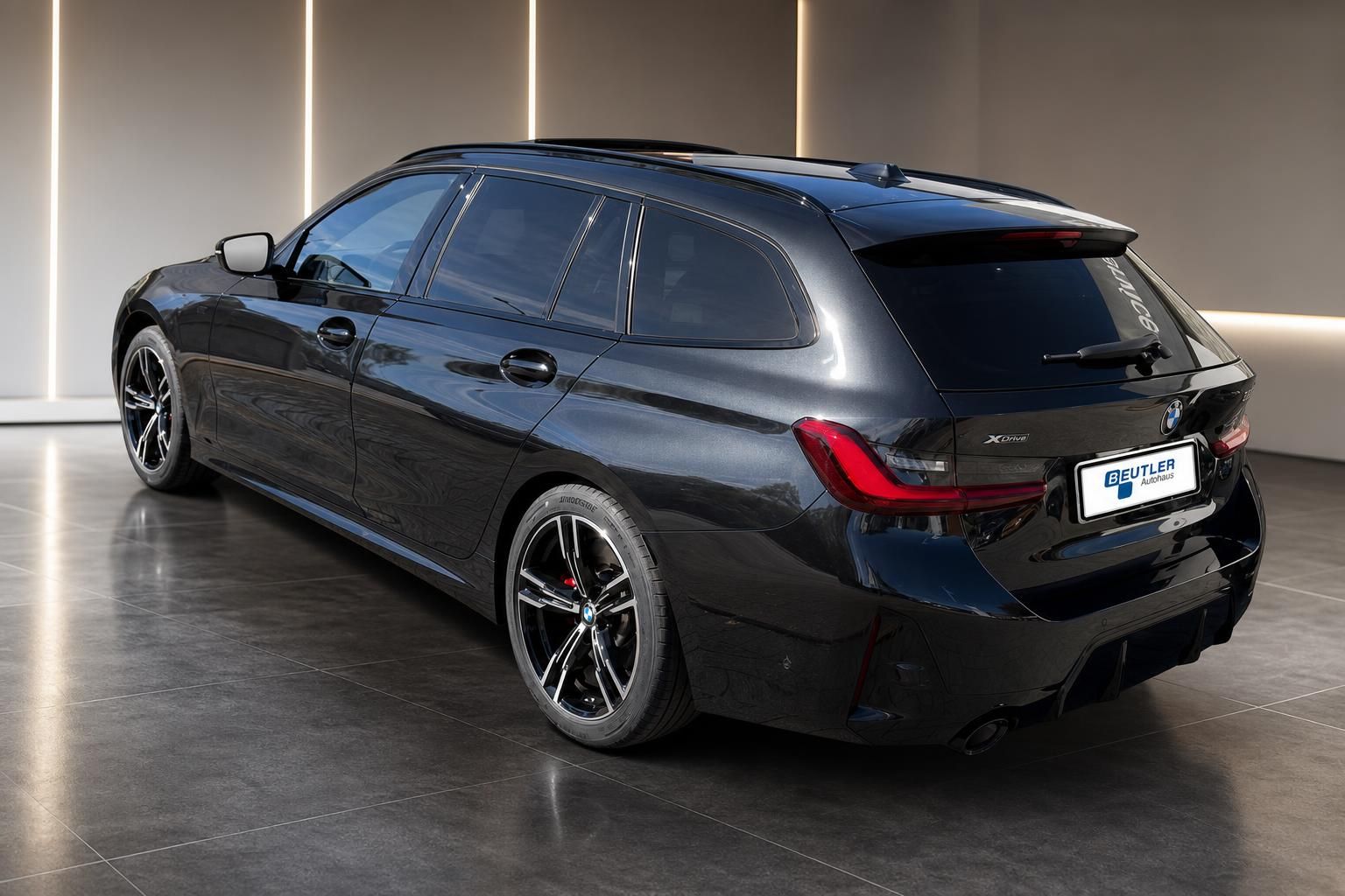 BMW 3er Touring schwarz, Heckansicht mit M-Felgen im Autohaus