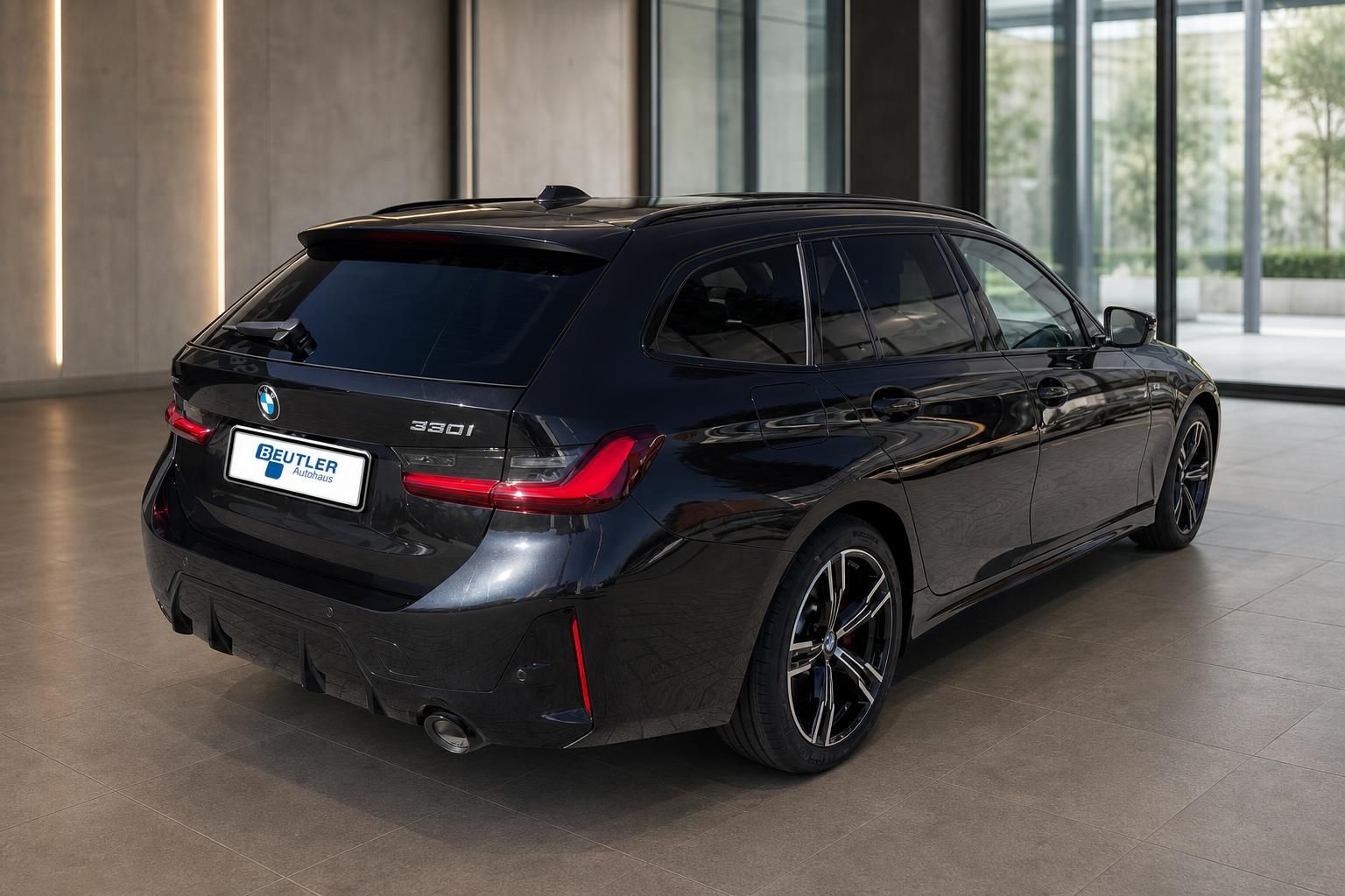 BMW 330i Touring schwarz, Heck-Seitenansicht im modernen Showroom