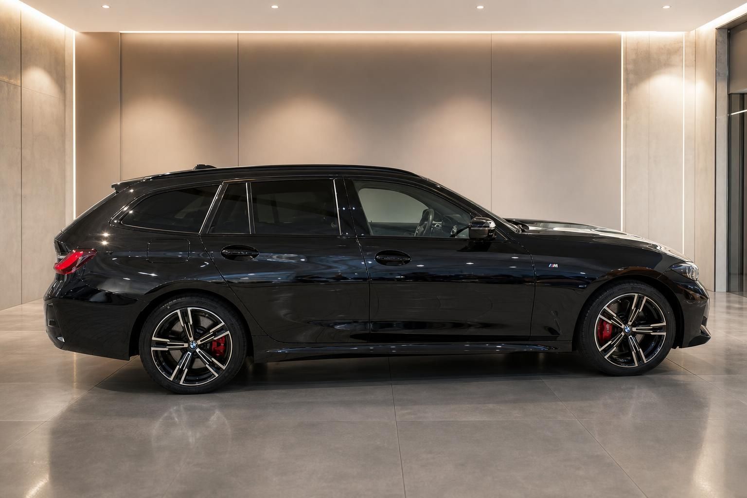 BMW 3er Touring schwarz Seitenansicht mit M-Felgen im Showroom