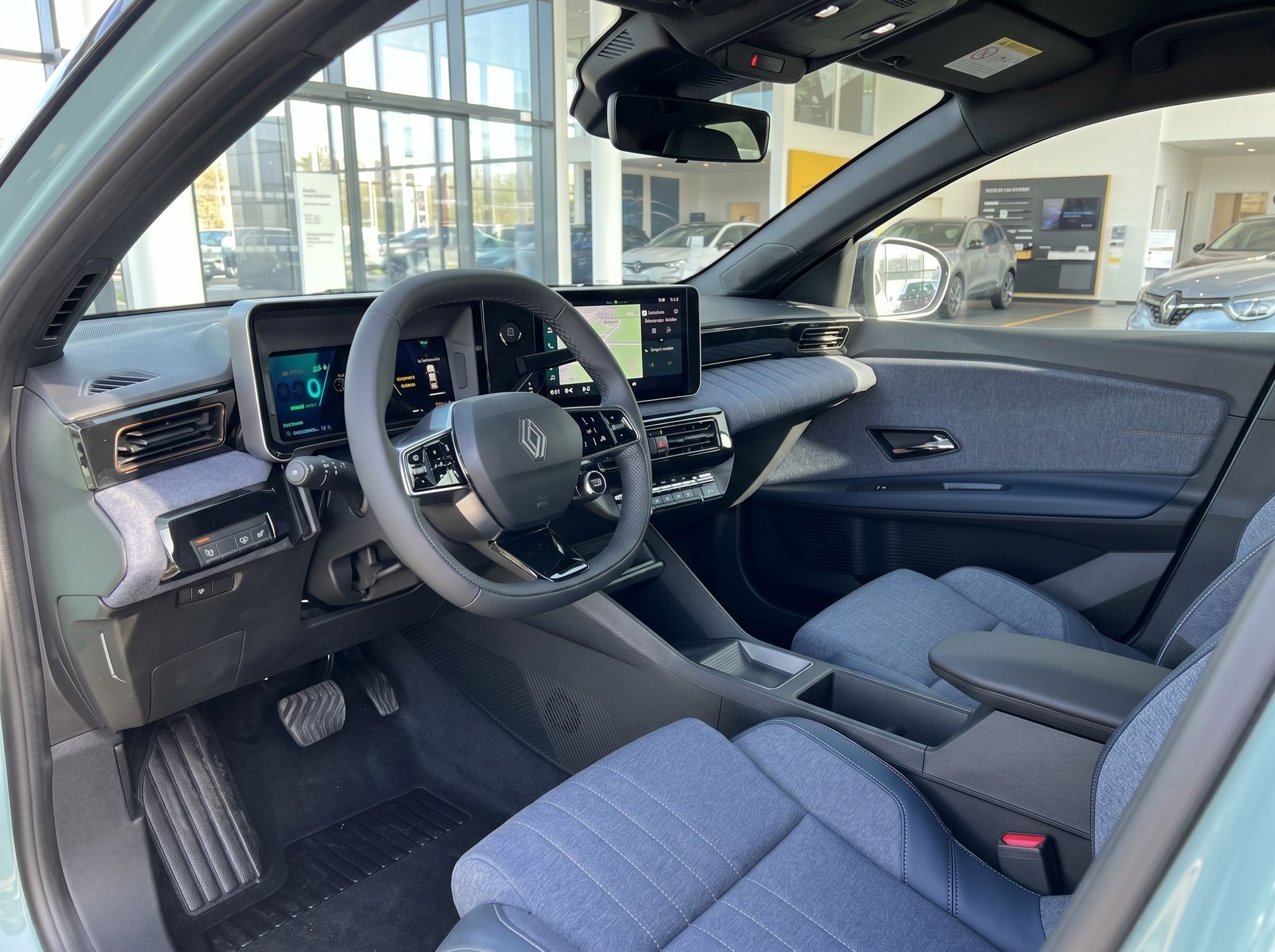 Innenraum Renault 4 E-Tech Electric - Cockpit mit digitalen Displays und Stoffsitzen in blau