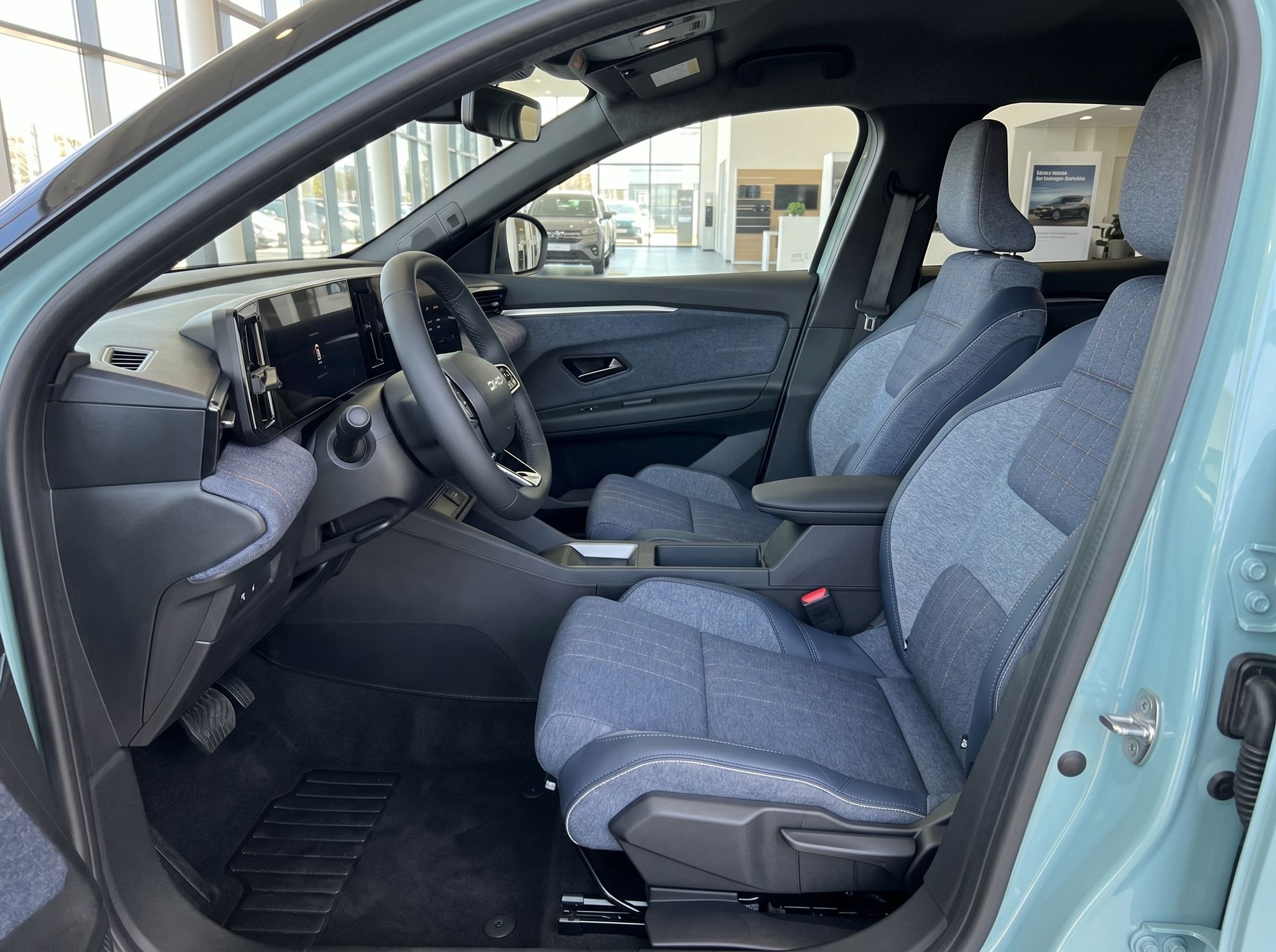 Renault Innenraum Fahrersitz mit grauer Stoffausstattung und Mittelkonsole - Seitliche Ansicht