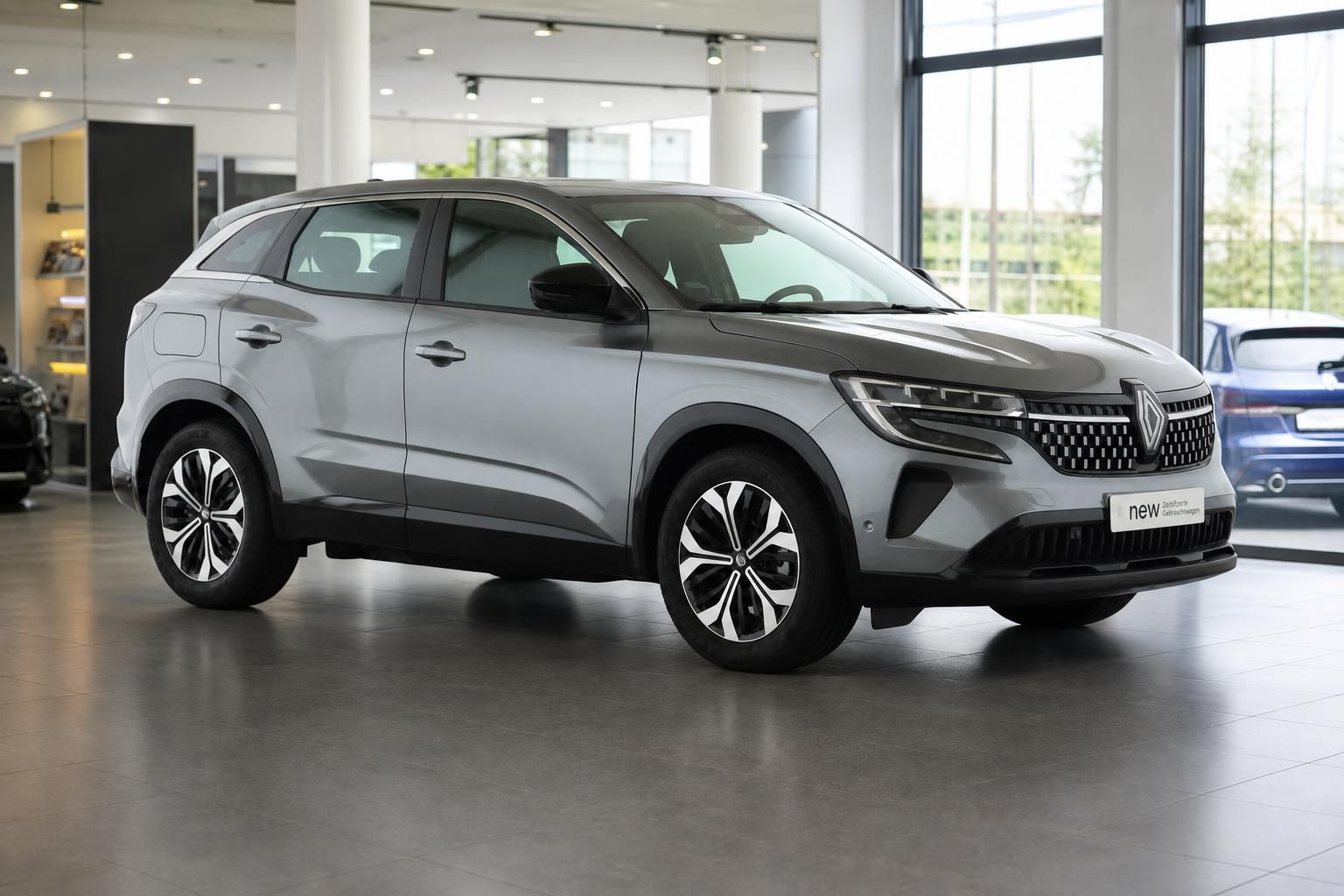 Silberner Renault SUV im Autohaus-Showroom, seitliche Dreiviertelansicht mit modernem Design