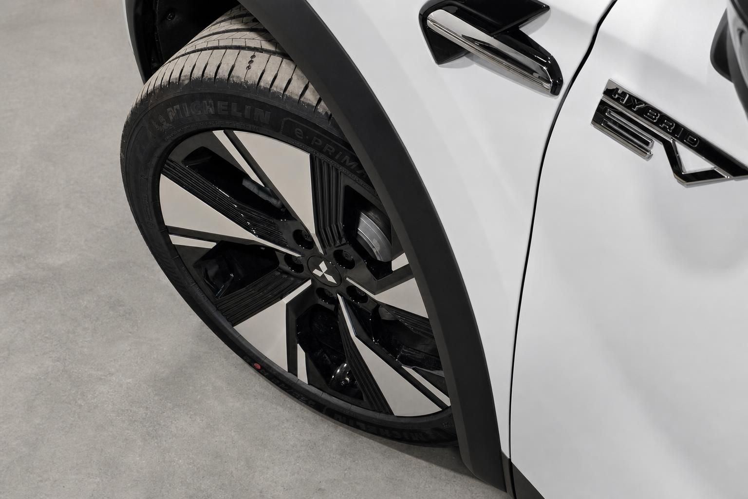 Mitsubishi Hybrid Leichtmetallfelge und Radlauf im Detail, weiß