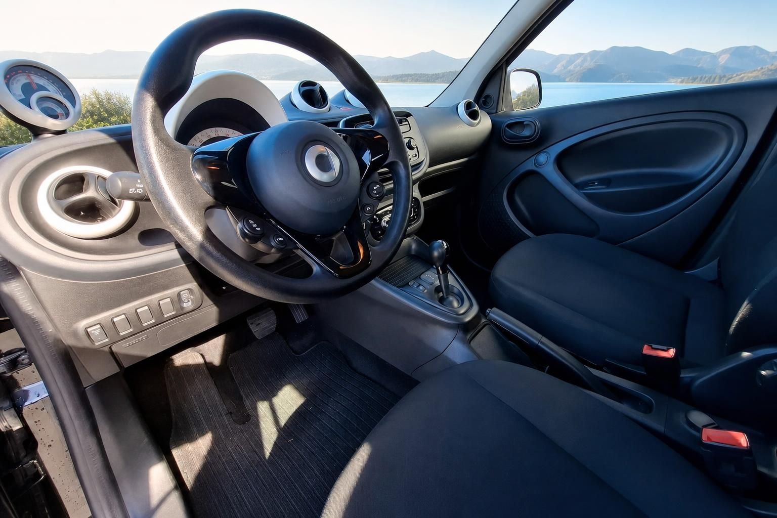 Fahrerkabine mit Lenkrad, Armaturenbrett und Berglandschaft im Hintergrund