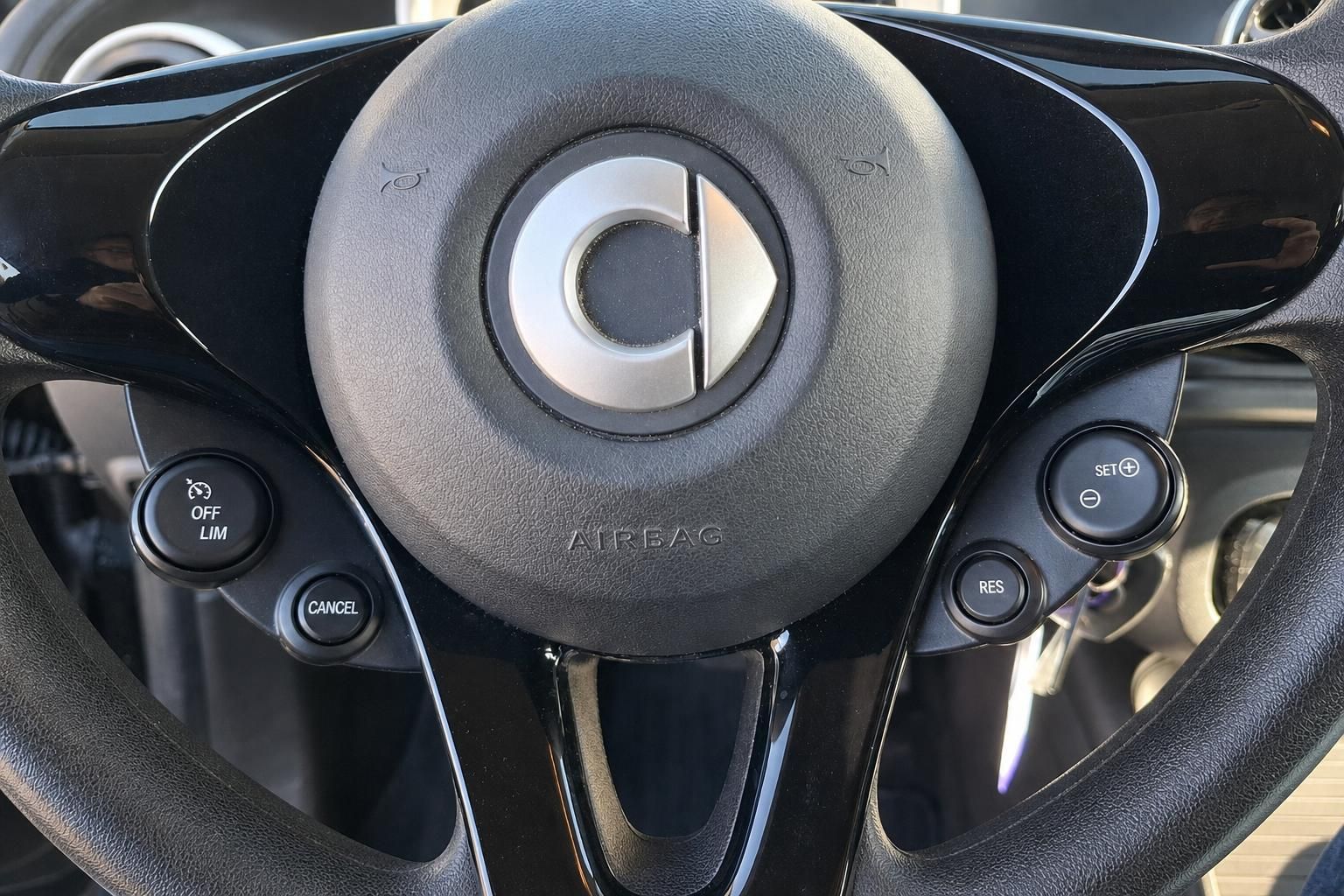 Lenkrad mit Airbag und Bedienungstasten im Fahrzeugcockpit