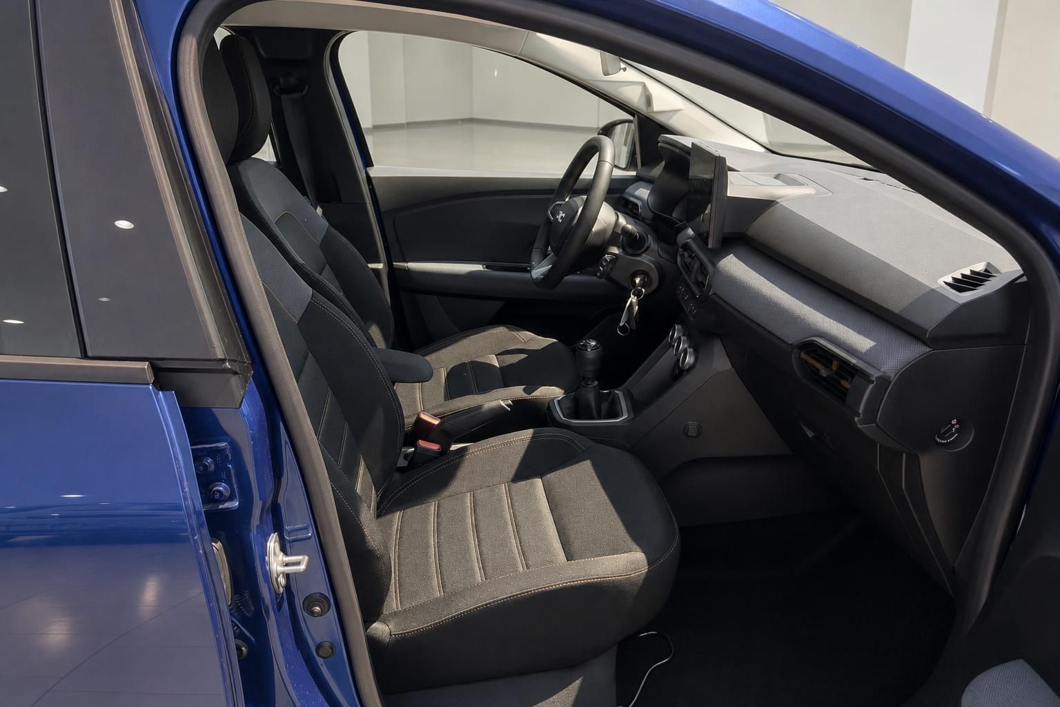 Dacia Innenraum Vordersitze und Cockpit mit Schaltgetriebe in Blau