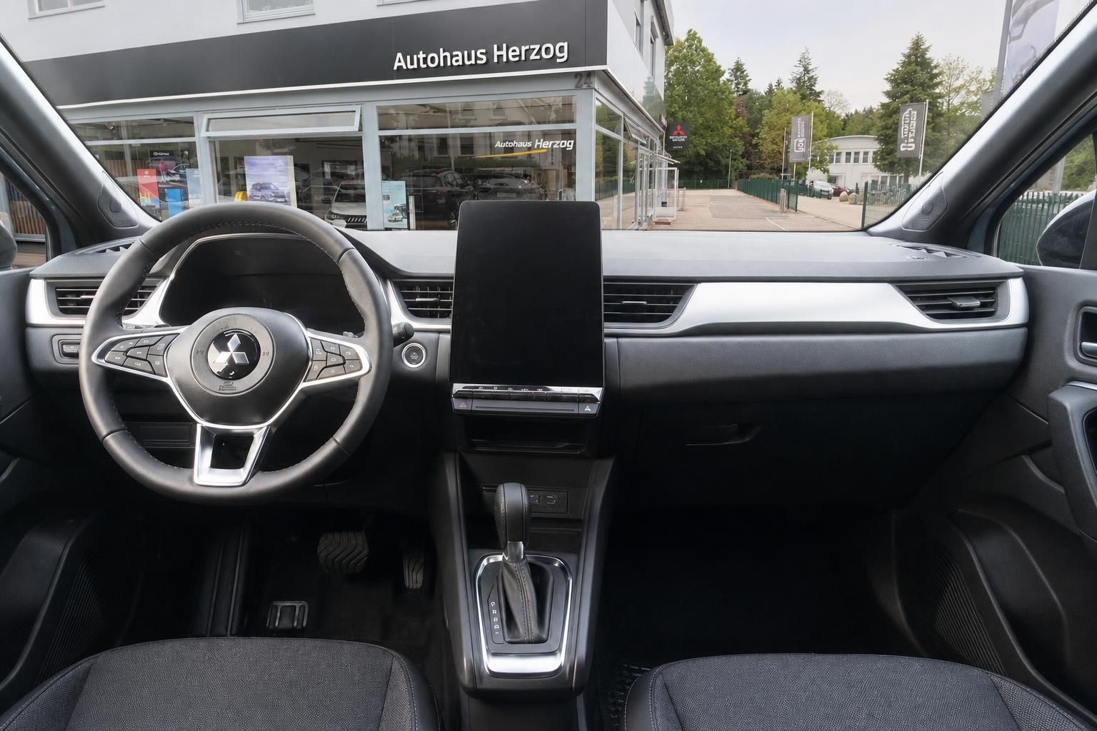 Fahrzeug Innenraum mit Lenkrad, Armaturenbrett und Display bei Autohaus Herzog