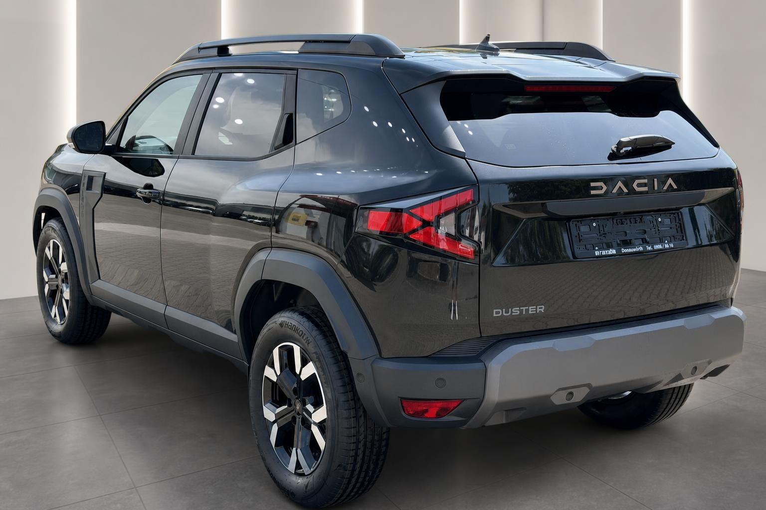 Dacia Duster schwarz Heckansicht schraeg im Showroom