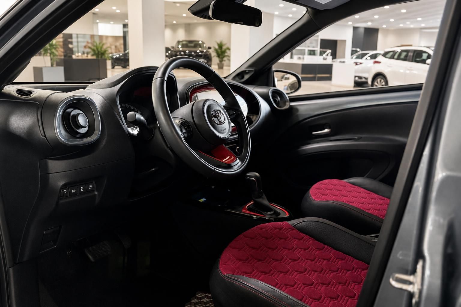 Toyota Aygo X Innenraum mit rot-schwarzen Sportsitzen und Lenkrad