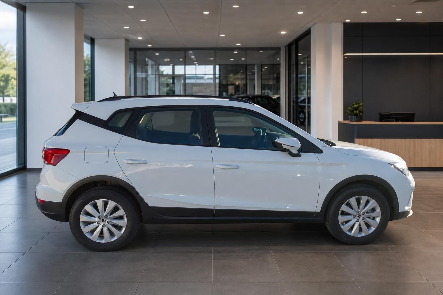 SEAT Arona weißer Crossover SUV Seitenprofil im modernen Autohaus mit großen Fensterfronten