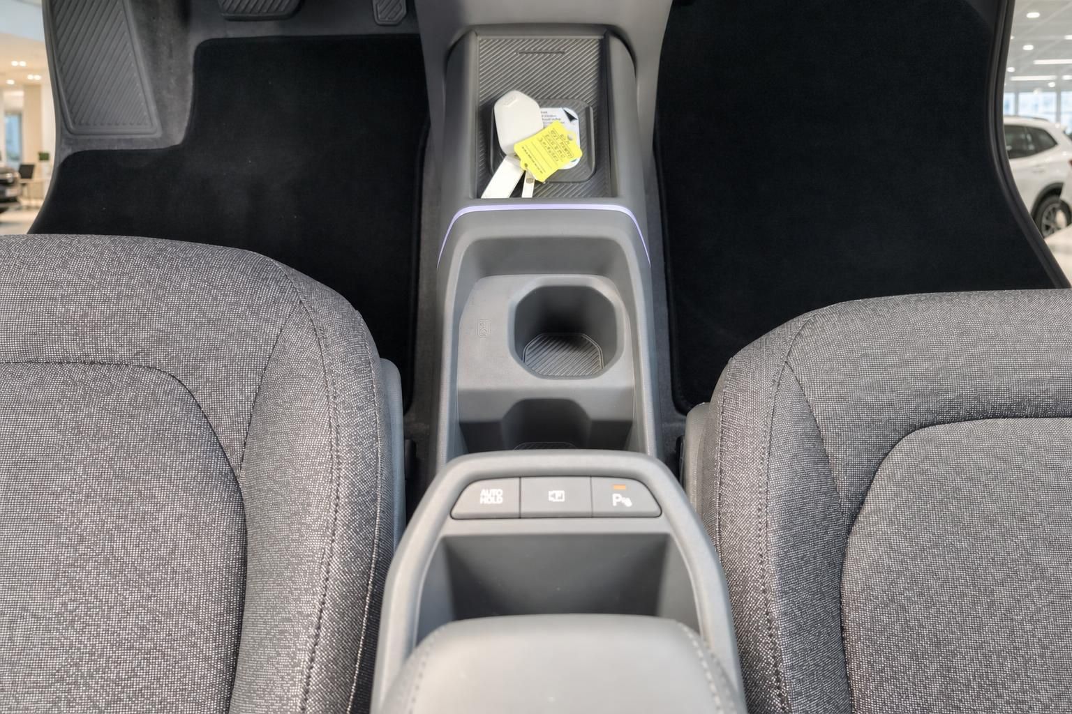 Mittelkonsole mit Becherhalter und Fahrzeugschlüssel im Kia Innenraum