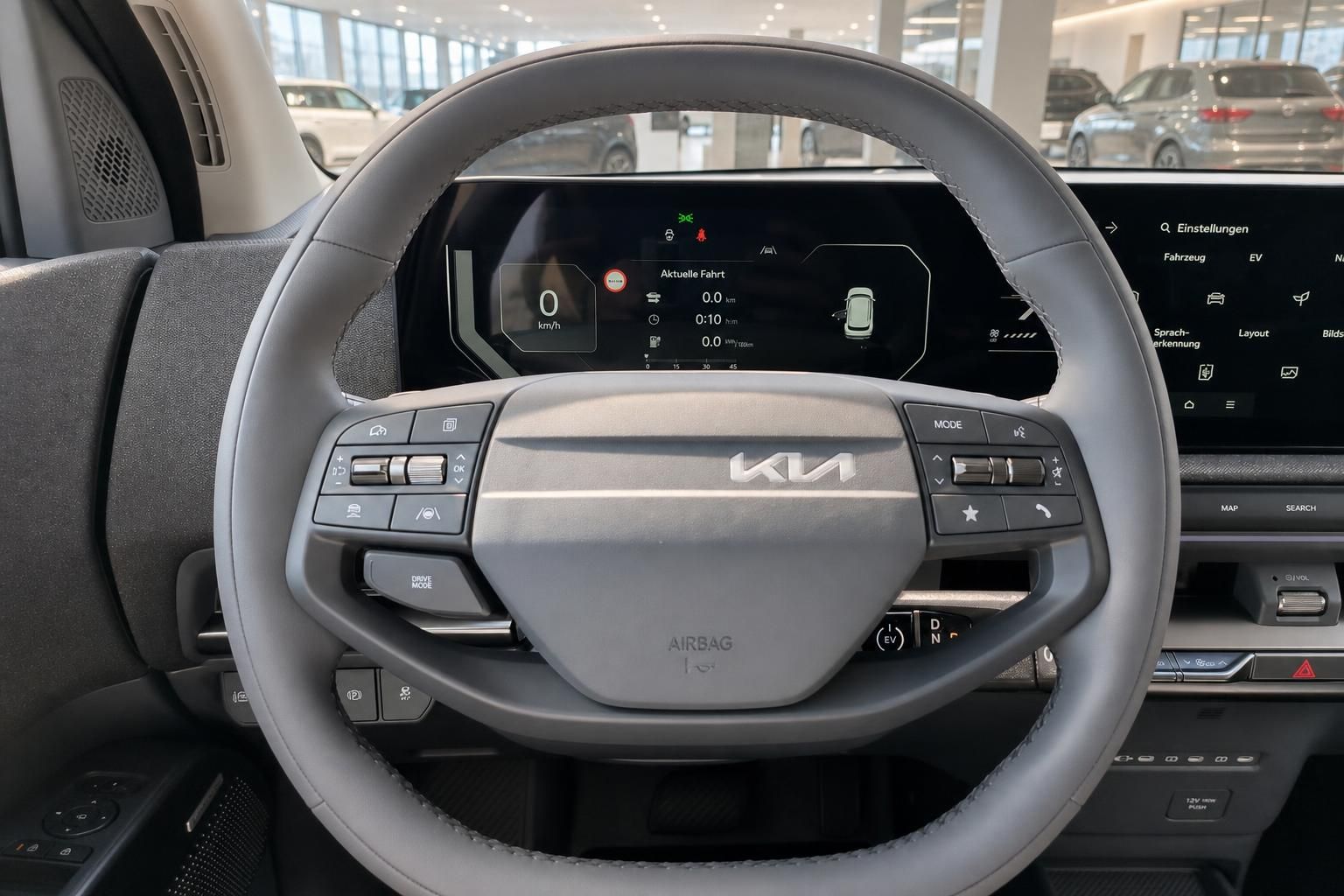 Lenkrad mit Kia Logo und digitalem Kombiinstrument im Cockpit