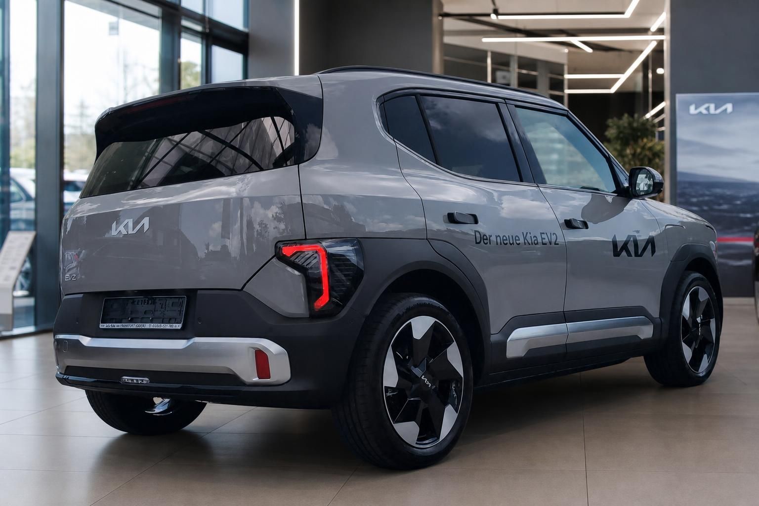 Kia EV2 grau Heck-Seitenansicht im Autohaus praesentiert