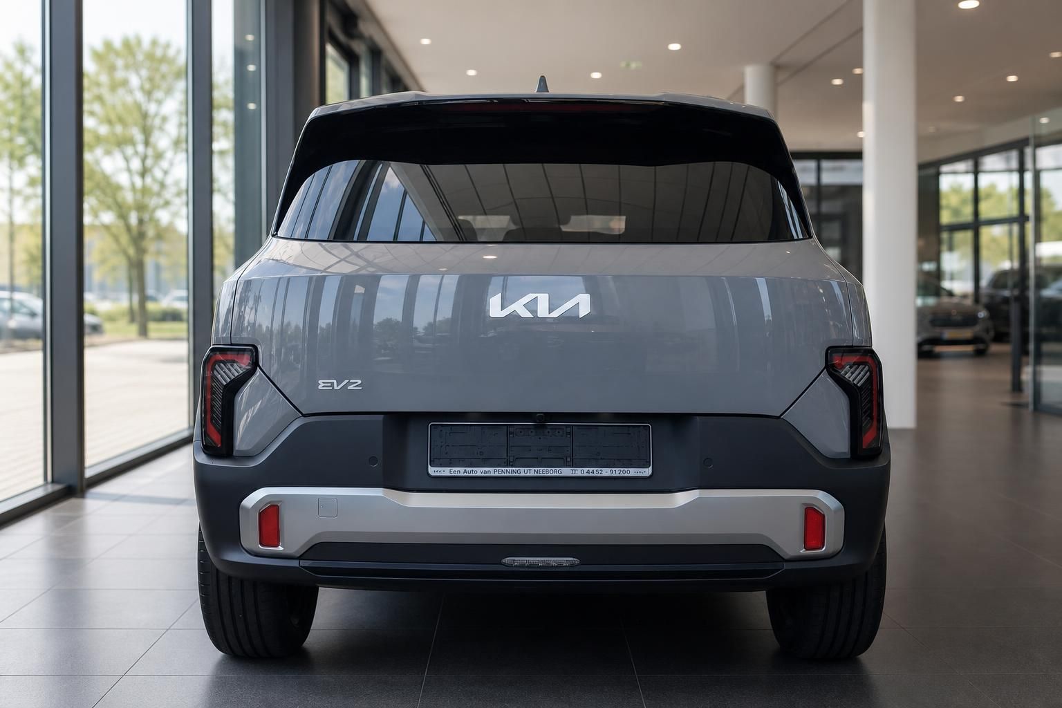 Kia EV2 grau Heckansicht mit Rueckleuchten im Showroom