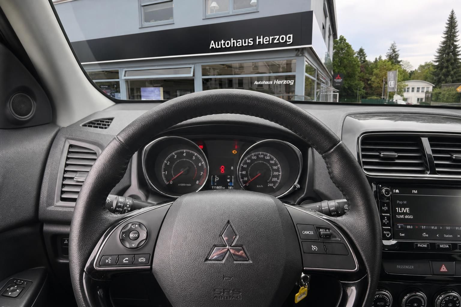 Mitsubishi Cockpit mit Tacho, Lenkrad und Infotainment-System - Detailansicht Armaturenbrett