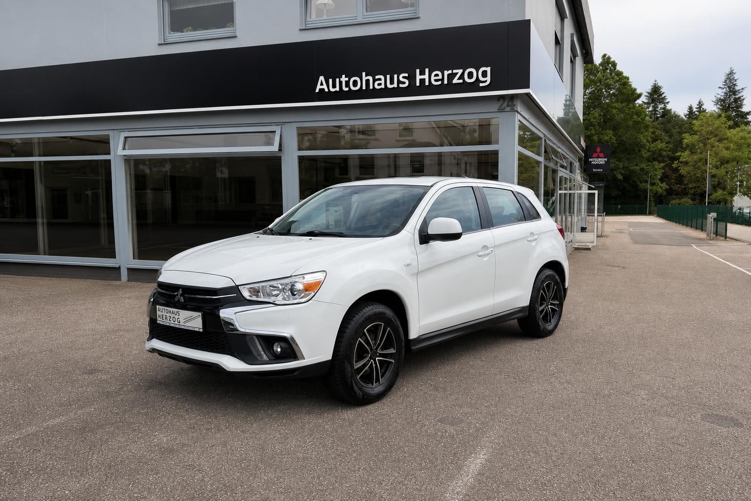 Weißer Mitsubishi ASX SUV Frontansicht vor Autohaus Herzog - Gebrauchtwagen kaufen