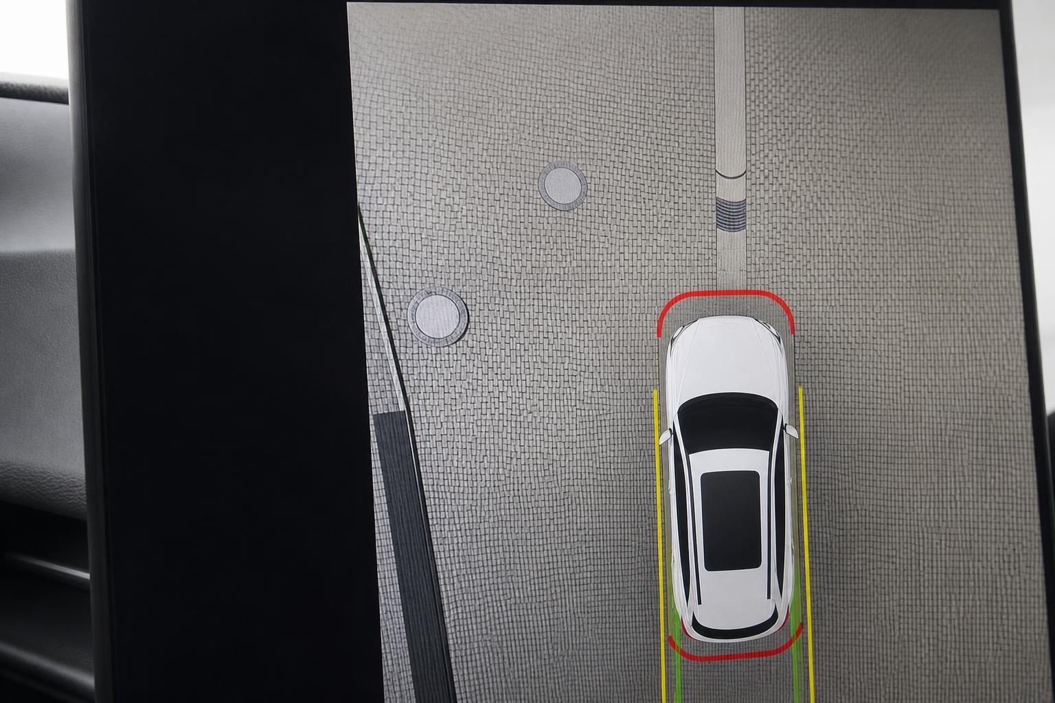 Fahrzeug Infotainment-Display zeigt Parkassistent mit Vogelperspektive und Hinderniswarnung