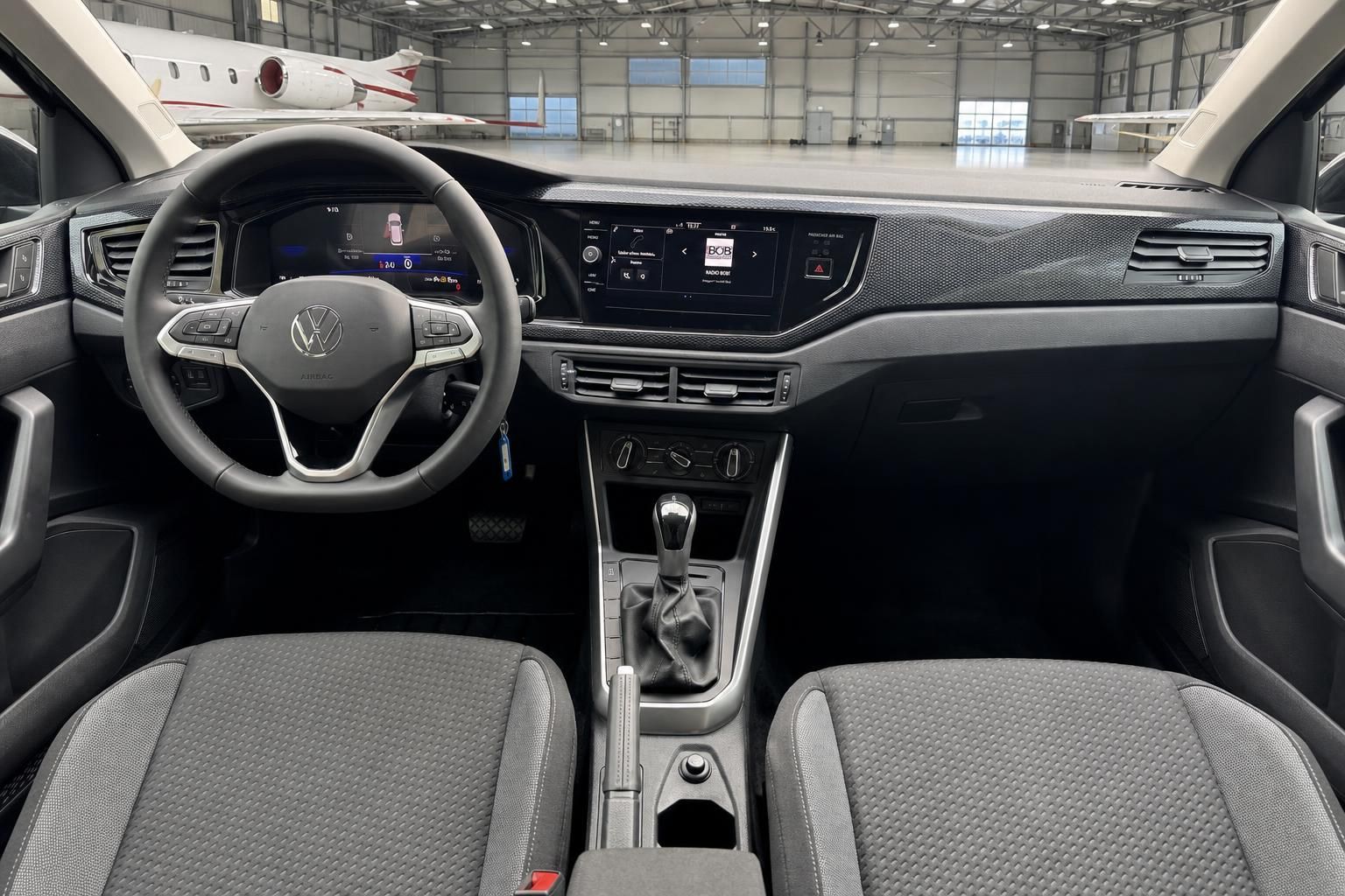 Volkswagen Innenraum mit grauem Dashboard, Lenkrad und Infotainment-Display