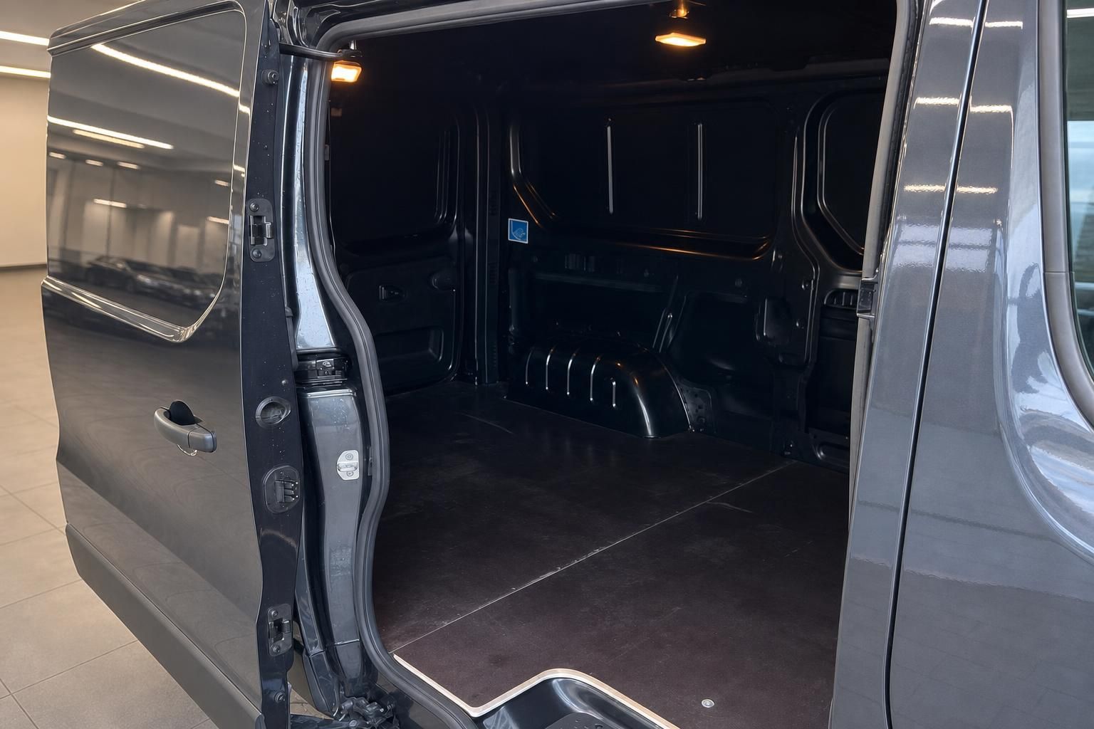Renault Transporter Laderaum mit offener Seitentür und schwarzer Bodenverkleidung im Showroom