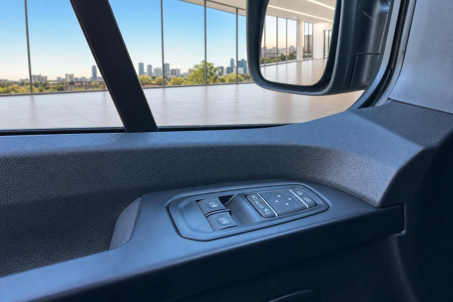 Fahrzeug Innenraum mit Fensterheberschalter und Stadtblick durch Seitenfenster