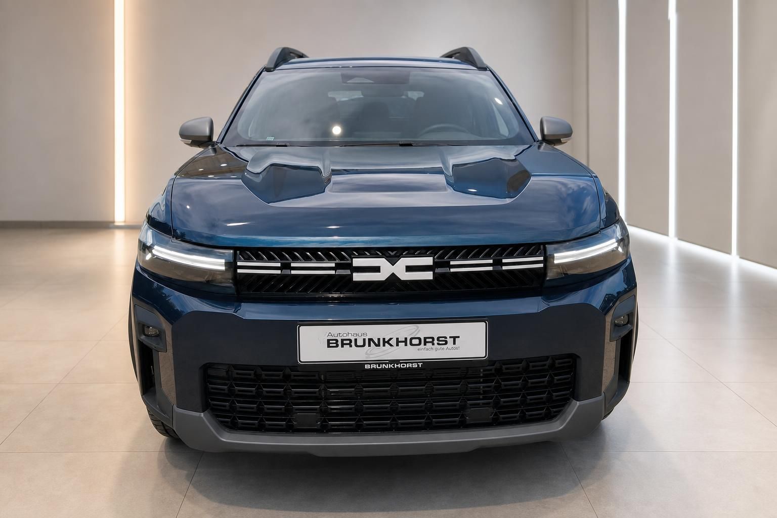 Dacia Bigster Hybrid SUV Frontansicht in Dunkelblau mit LED-Tagfahrlicht im Autohaus