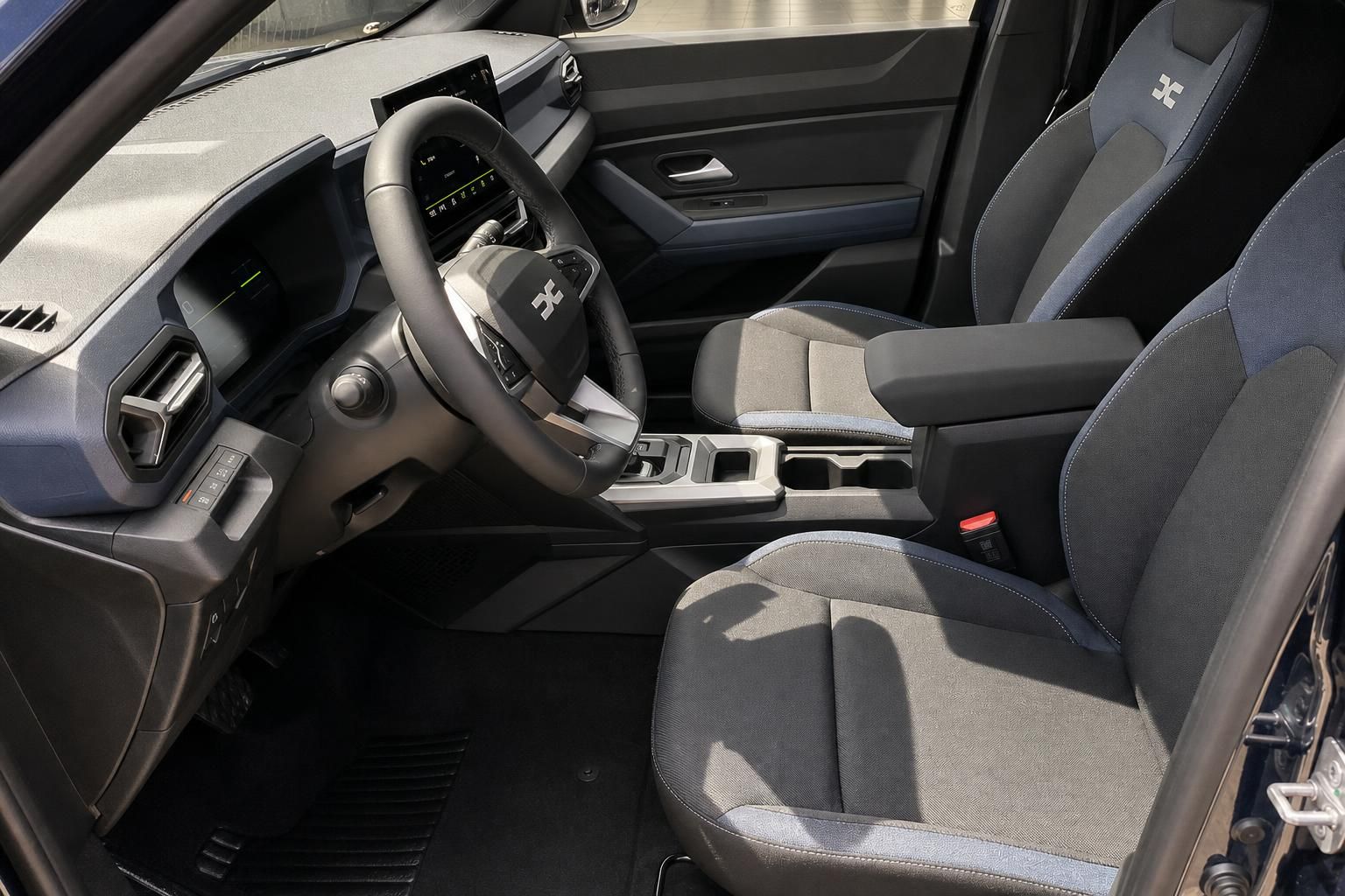 Dacia Bigster Hybrid Innenraum Fahrersitz Lenkrad und Mittelkonsole in Grau-Schwarz